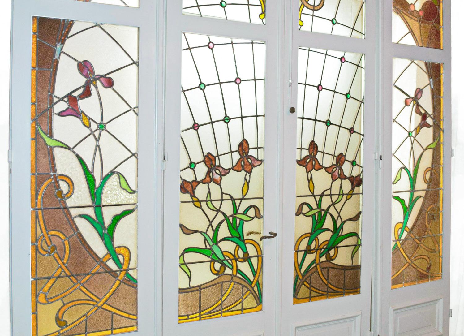 Un meraviglioso set di otto vetrate francesi a quattro ante con maniglie in bronzo. Il set di otto pannelli è in vetro colorato in vetro policromo con persiane, serrature, maniglia e chiave originale.  

Bellissima vetrata del periodo Art Nouveau