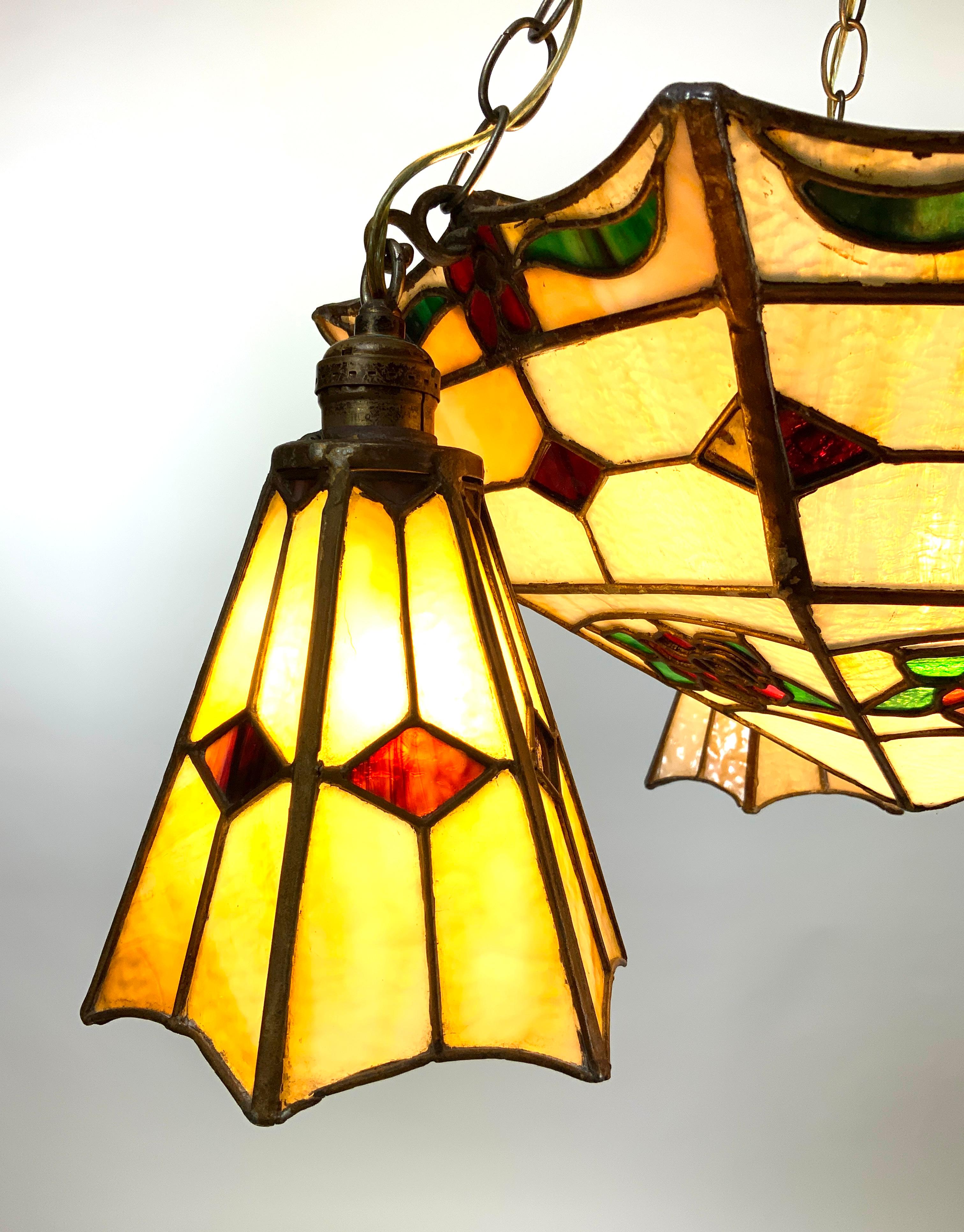 This stunning stained glass Art Nouveau pendant faceted chandelier is in excellent condition. No chips, cracks or visible damage. It has been tested and is working perfectly.

The colours of the stained glass are clear and vibrant. There are 2 roses