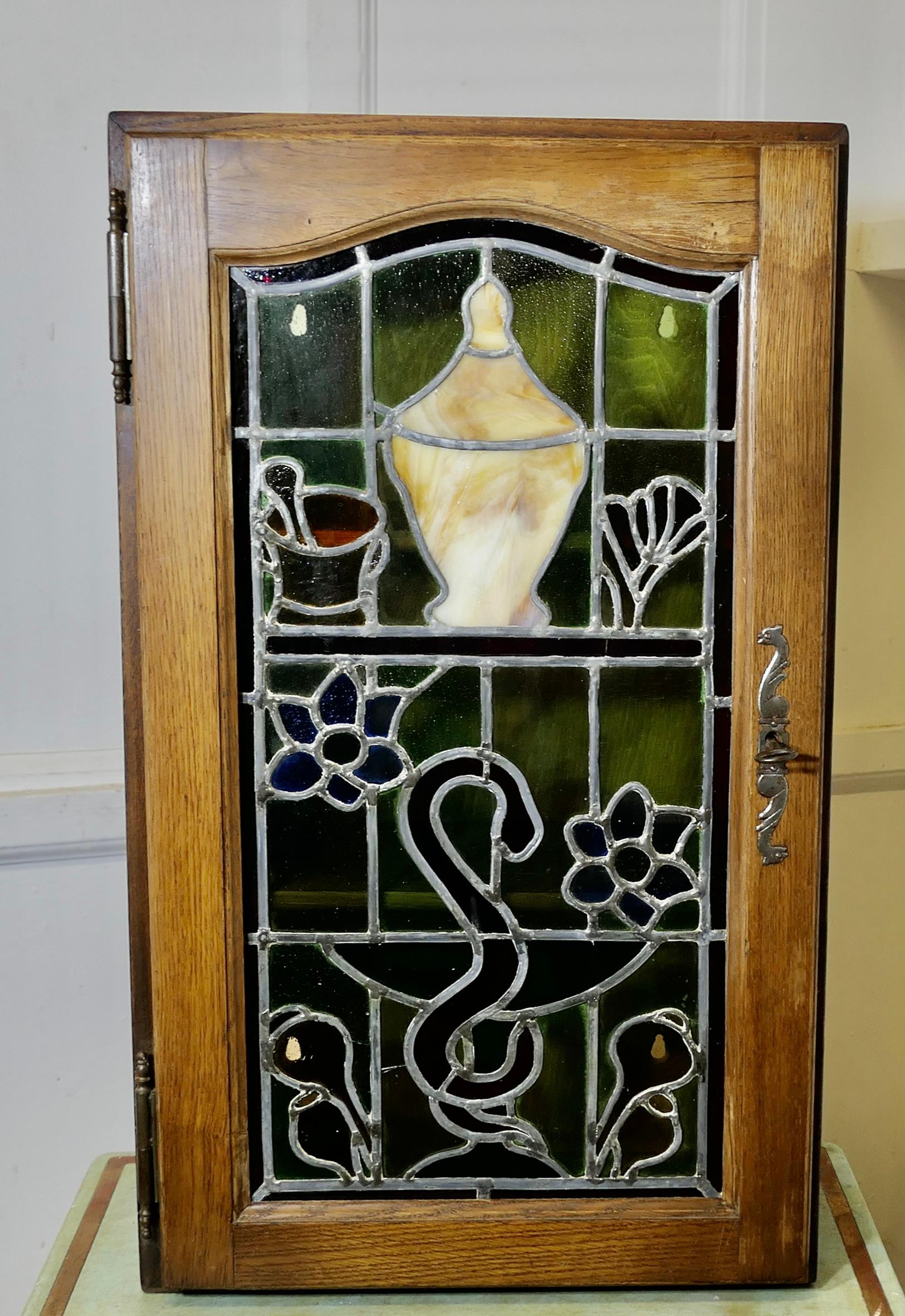 Armoire de pharmacie ou de salle de bains Art Nouveau  

Il s'agit d'une pièce magnifique qui se montre sous son meilleur jour avec une lumière à l'intérieur du meuble. Elle présente un très beau travail de plomb détaillé représentant un pilon et un