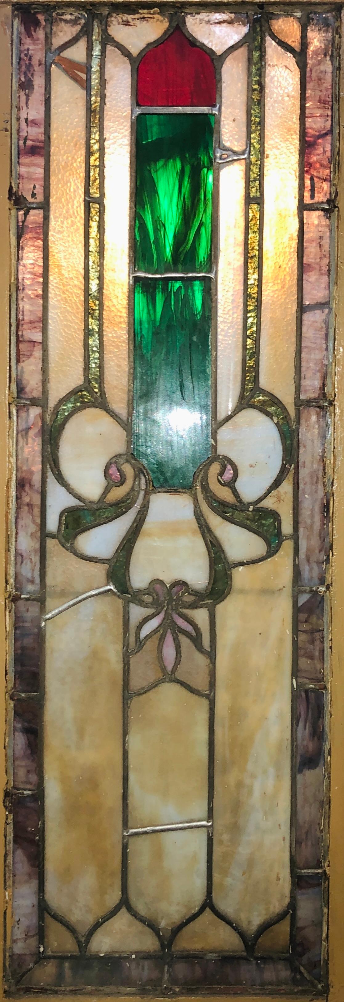 Cette fenêtre étonnante est remplie de panneaux aux couleurs vives, créant un design art nouveau. Des verts et des rouges profonds dans un cadre jaune marbré.
Actuellement dans un cadre en bois - les dimensions totales sont celles du vitrail et du