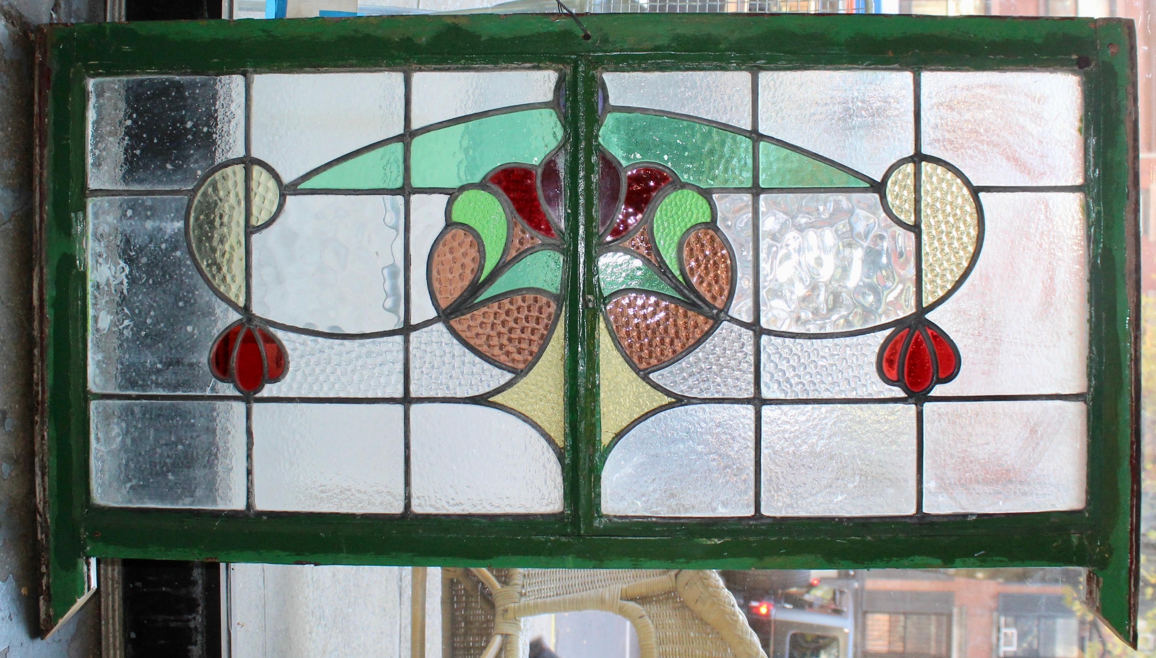Design/One coloré dans une fenêtre en verre transparent texturé. Cette imposte contient deux fenêtres divisées par un cadre en bois.
Actuellement dans un cadre en bois - les dimensions totales sont celles du vitrail et du cadre.
Situé à NY