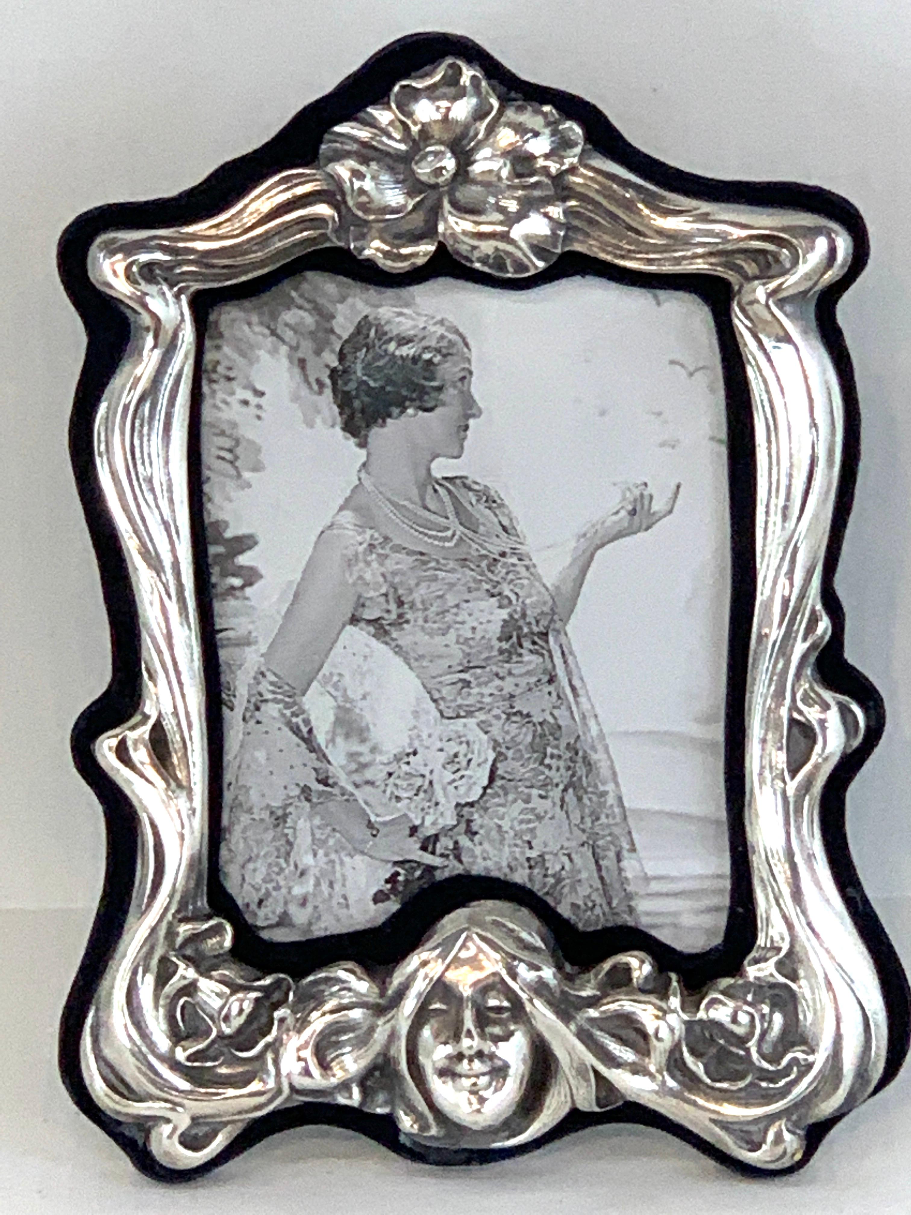 Art Nouveau sterling lady motif figural frame, of exceptional size and quality, the flowing floral surround with central maiden medallion head at the base. Holds a 5