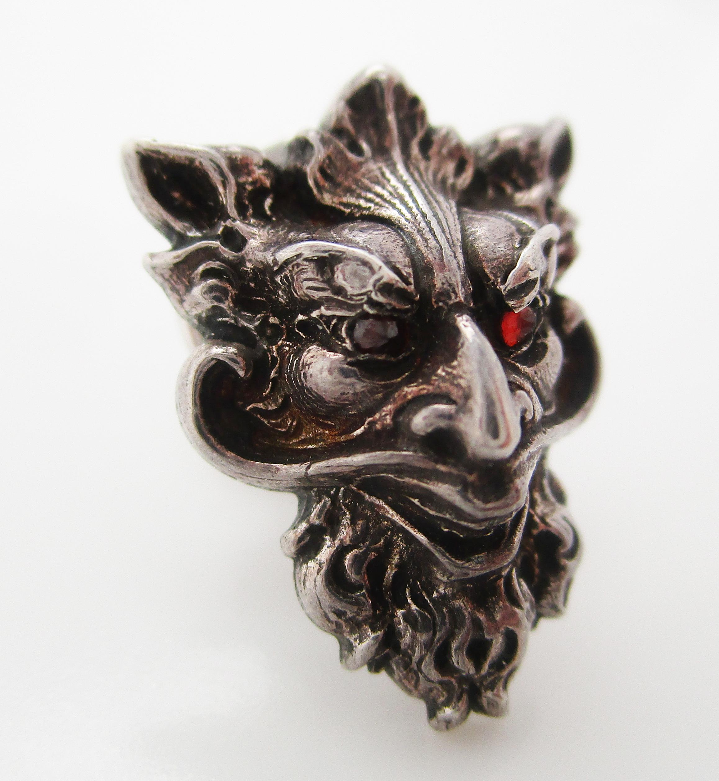 This awesome sterling silver Art Nouveau pin is in the shape of a grotesque devil’s face with rose-cut garnet eyes!
The details in this pin are incredible. The lines of the goblin’s face and smile are long and curving - definitive Art Nouveau! The