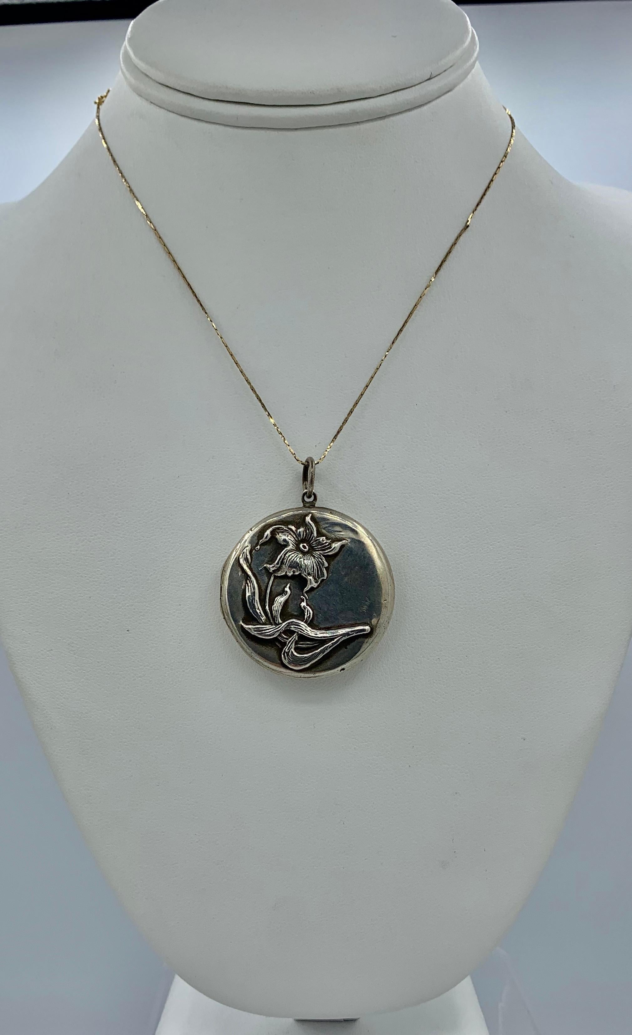 THIS IS A GORGEOUS ART NOUVEAU LOCKET PENDANT IN STERLING SILVER WITH A BEAUTIFUL DEEP REPOUSSE DESIGN OF A LILY FLOWER AND LEAVES.
This is just a stunning sterling silver lily flower motif locket with exquisite Art Nouveau design.  The beautiful