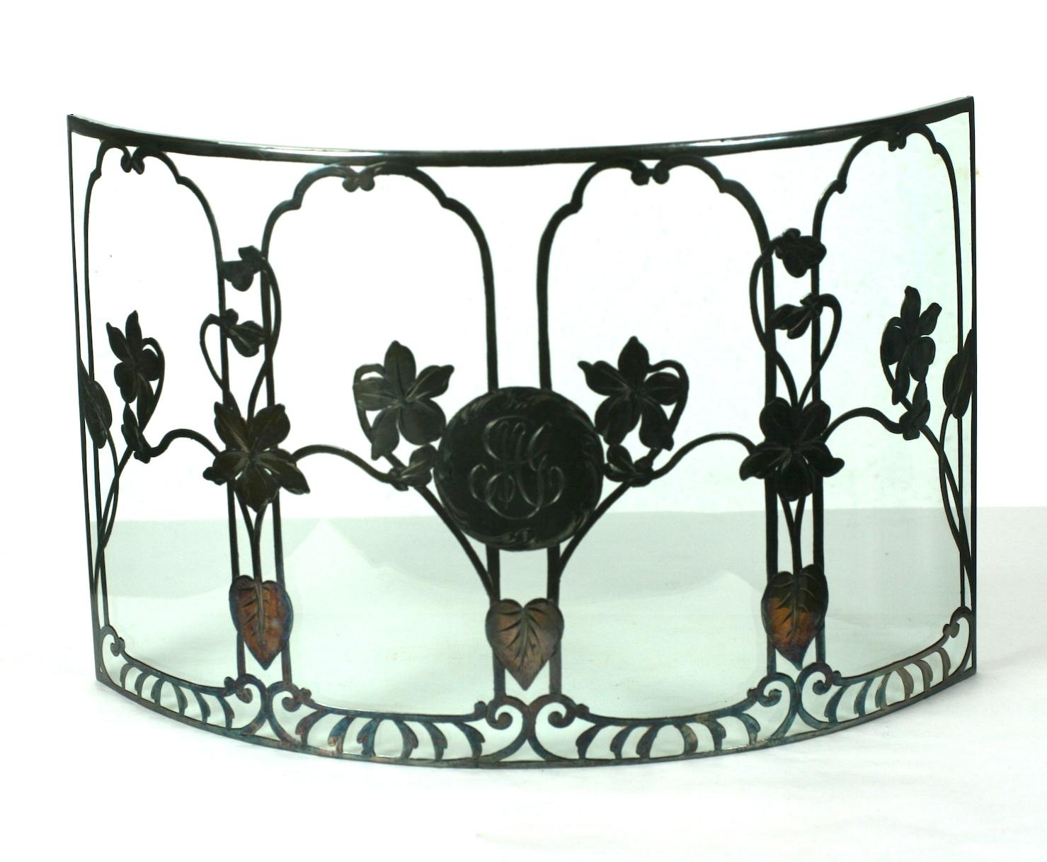 Sterling Silver overlay candle guard from the early 20th century. Art Nouveau sterling violet floral patterns fused to a curved panel of glass with central monogram. Designed for the table behind which candles were lit. Measures: 10.5
