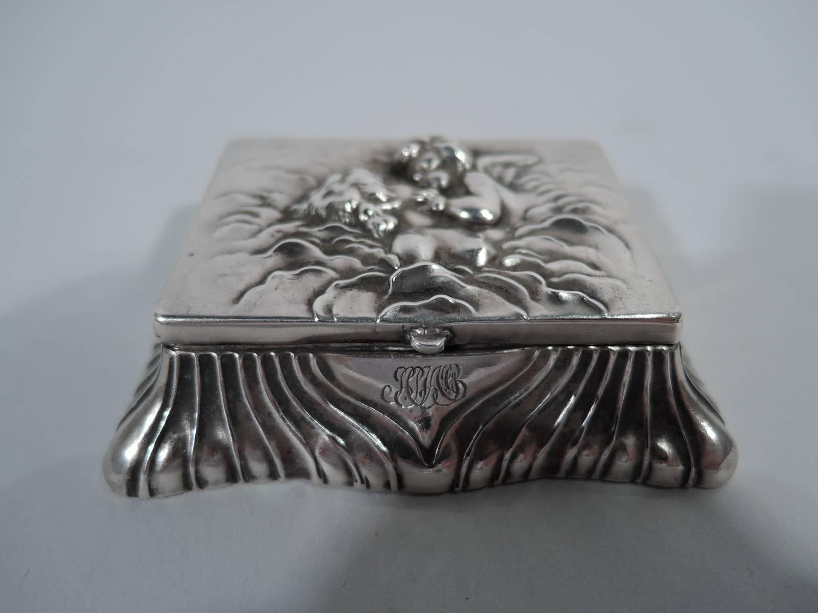 Art Nouveau sterling silver postage stamp box. Made by Unger Bros in Newark. Rectangular cover with mythological scene in low relief: Cupid kisses Venus on wavy cloud ground. Cover hinged to undulating and fluted spread base. Interlaced script
