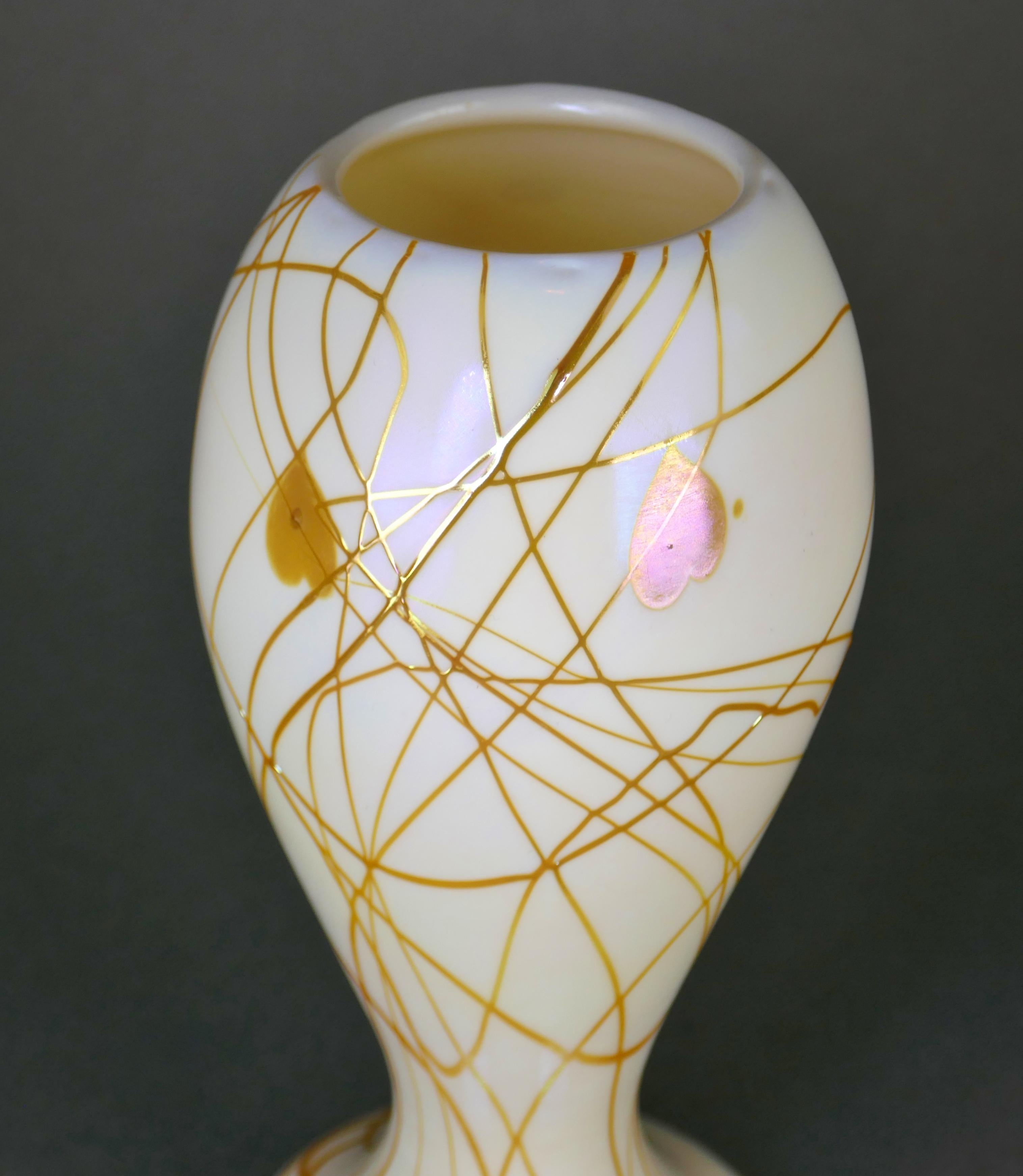 Stunning Circa 1925 Art Nouveau Glass Vase by Steuben Glass Works of Corning N.Y. The vase retains a very uncommon Fleur-de-lis paper label. It has an iridescent cream body threaded with an Aurene vine and heart design—no chips, cracks, or repairs. 