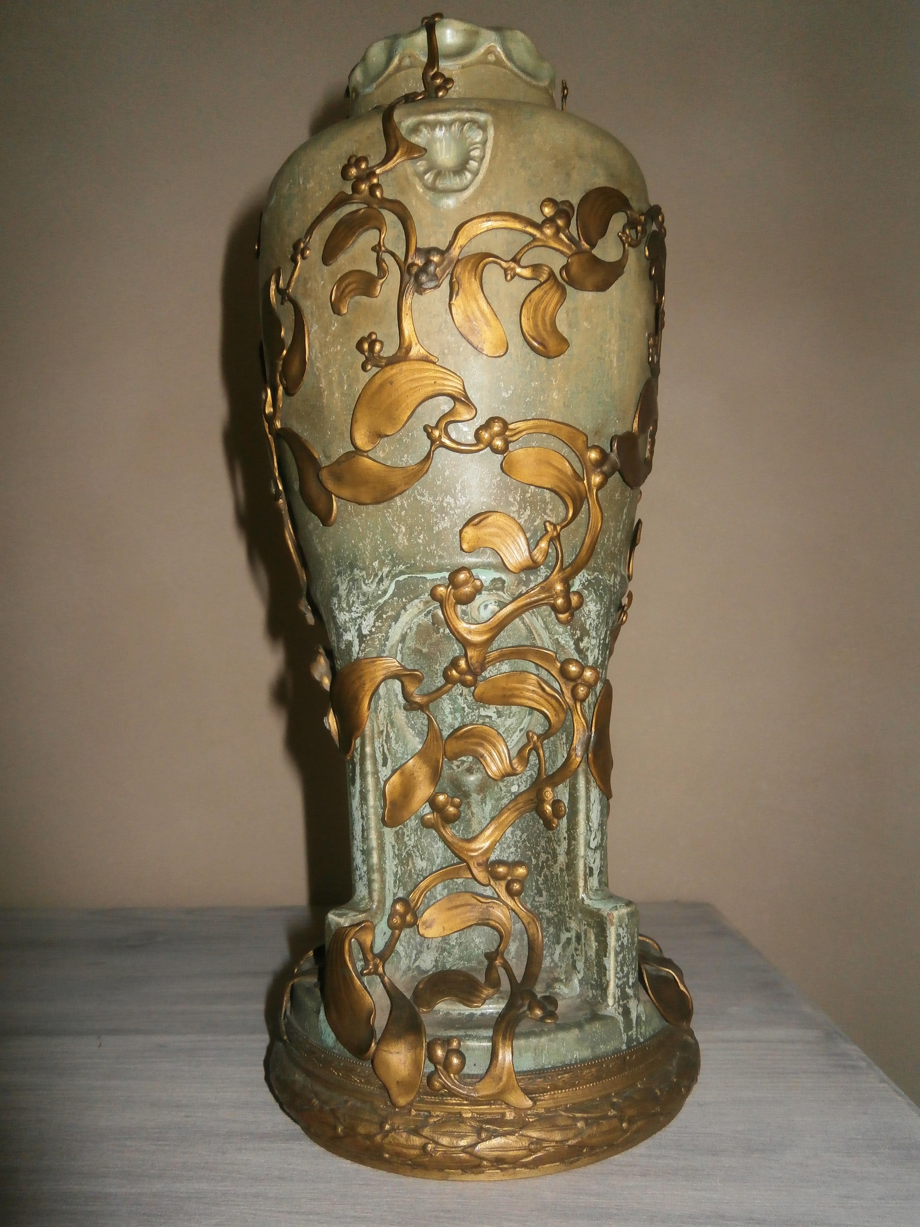 Large stoneware vase in an extraordinary brass frame decorated with mistletoe branches.