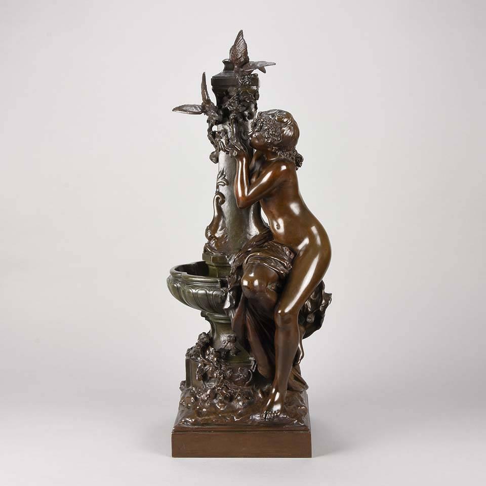 A fabulous late 19th century Art Nouveau bronze figure of a young seated beauty drinking from a watering fountain with birds around the top of the central pillar. The bronze surface with excellent rich brown patina and fine detail, signed Math