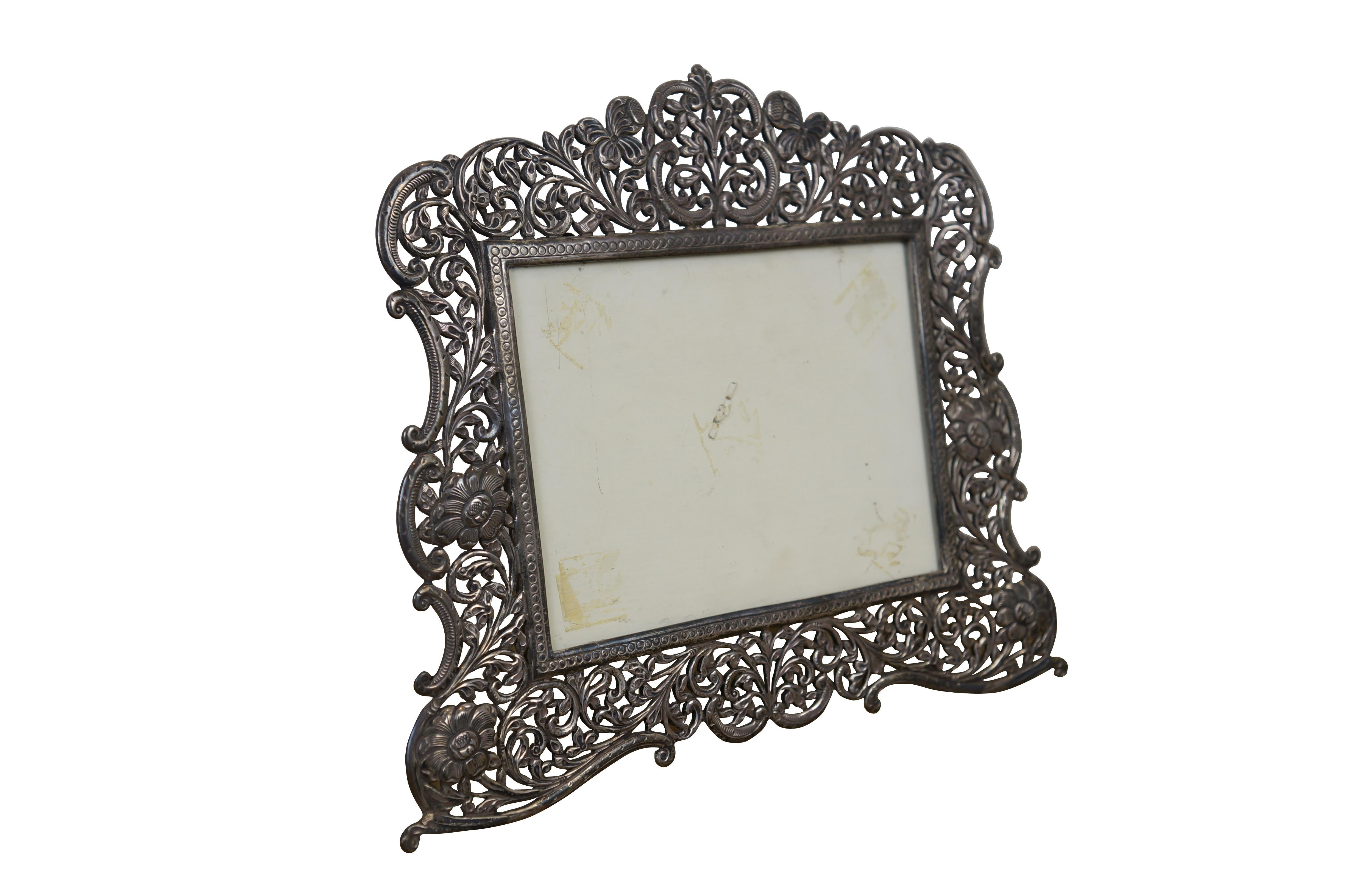 Cornice rettangolare orizzontale in stile art nouveau in argento 925 con filigrana floreale e fogliare traforata. Retro del cavalletto. 

Dimensioni:
12