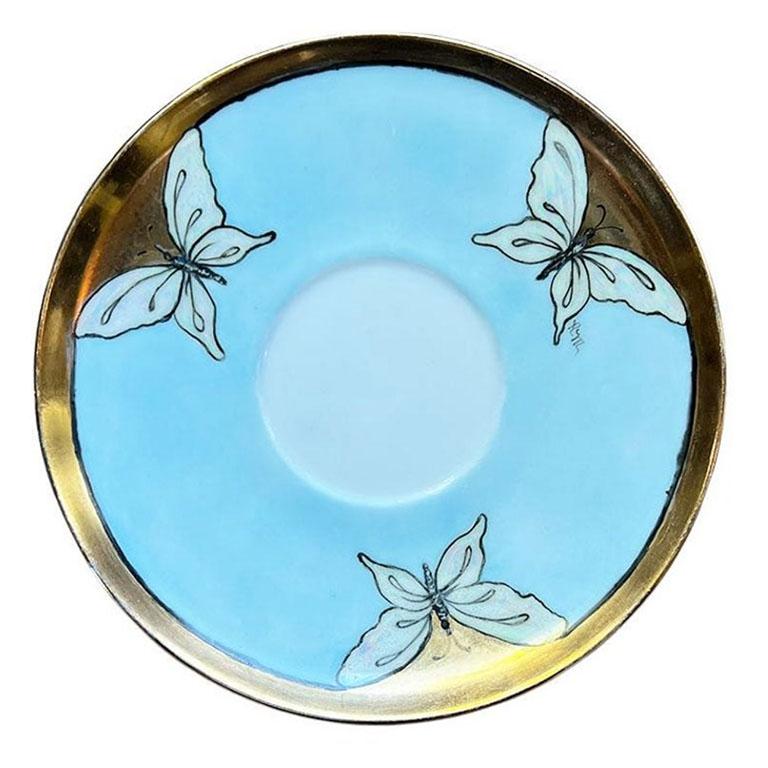 A round ceramic Art Nouveau butterfly saucer by Paul McCobb for Contempri. We've seen Paul McCobb ceramics before, but we've never come across a piece like this. The outer edges are painted in a bright gold and is accented with pearlized white