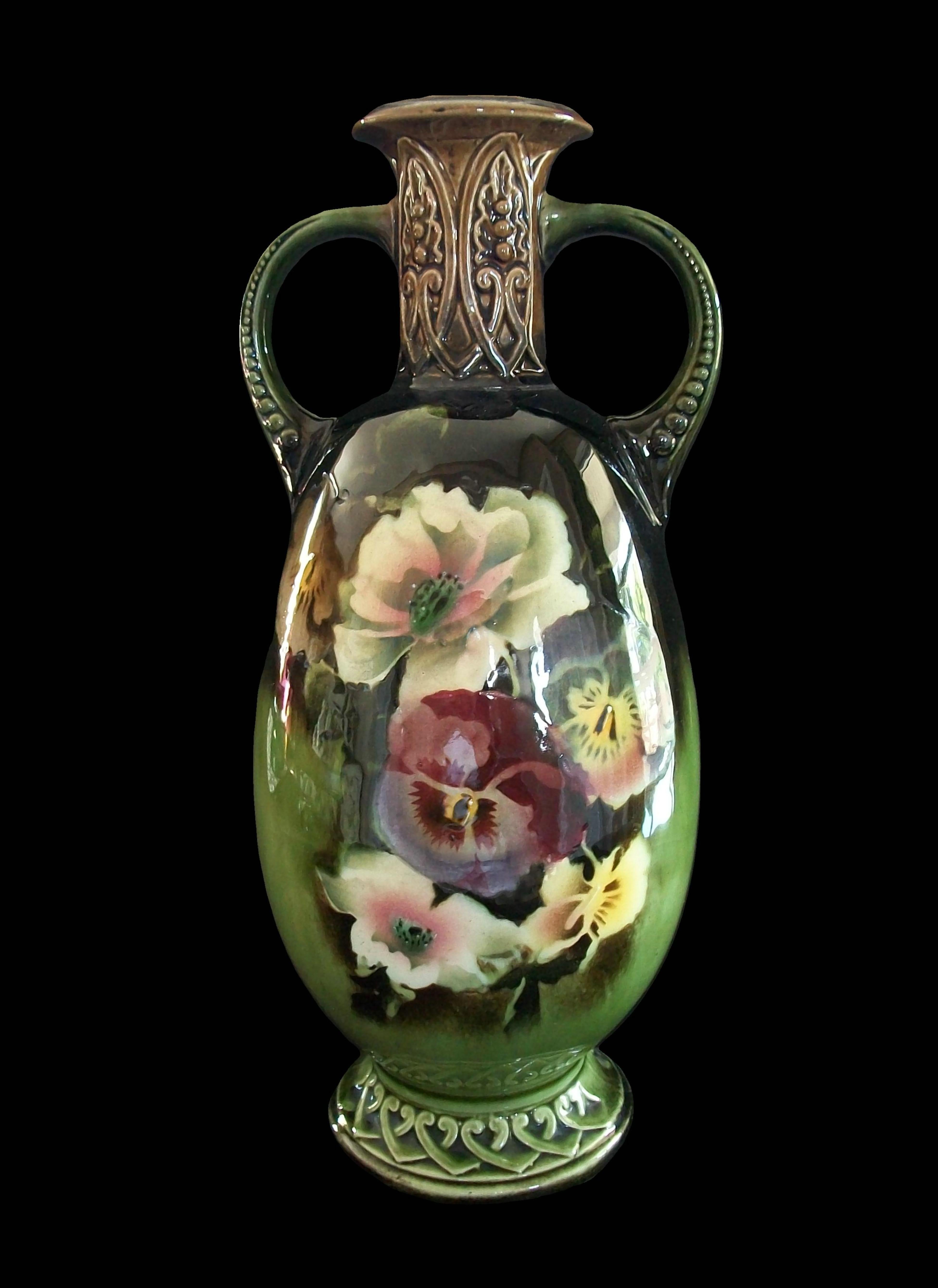 Vintage Art Nouveau style hand painted twin handled ceramic vase - featuring a cast ceramic body with embossed patterns to the neck, base and handles - airbrushed, stenciled and hand painted floral decoration to the front of the bulbous body -