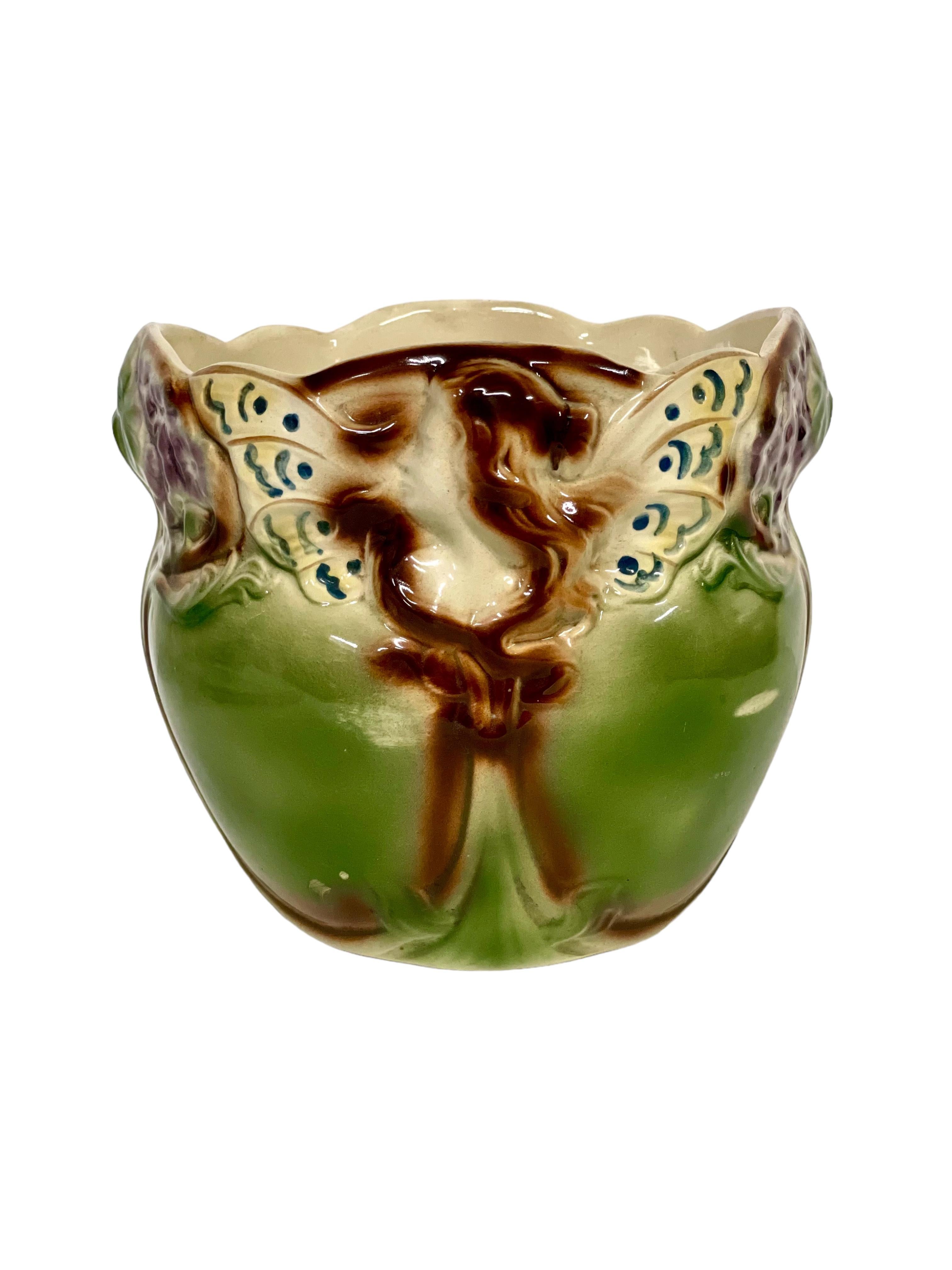 A pretty 19th century Majolica cache pot, decorated in shades of green and brown, and featuring the vivid colouration, whimsical shapes and high-relief sculpture typical of the style. Art Nouveau in design, this glazed earthenware pot would