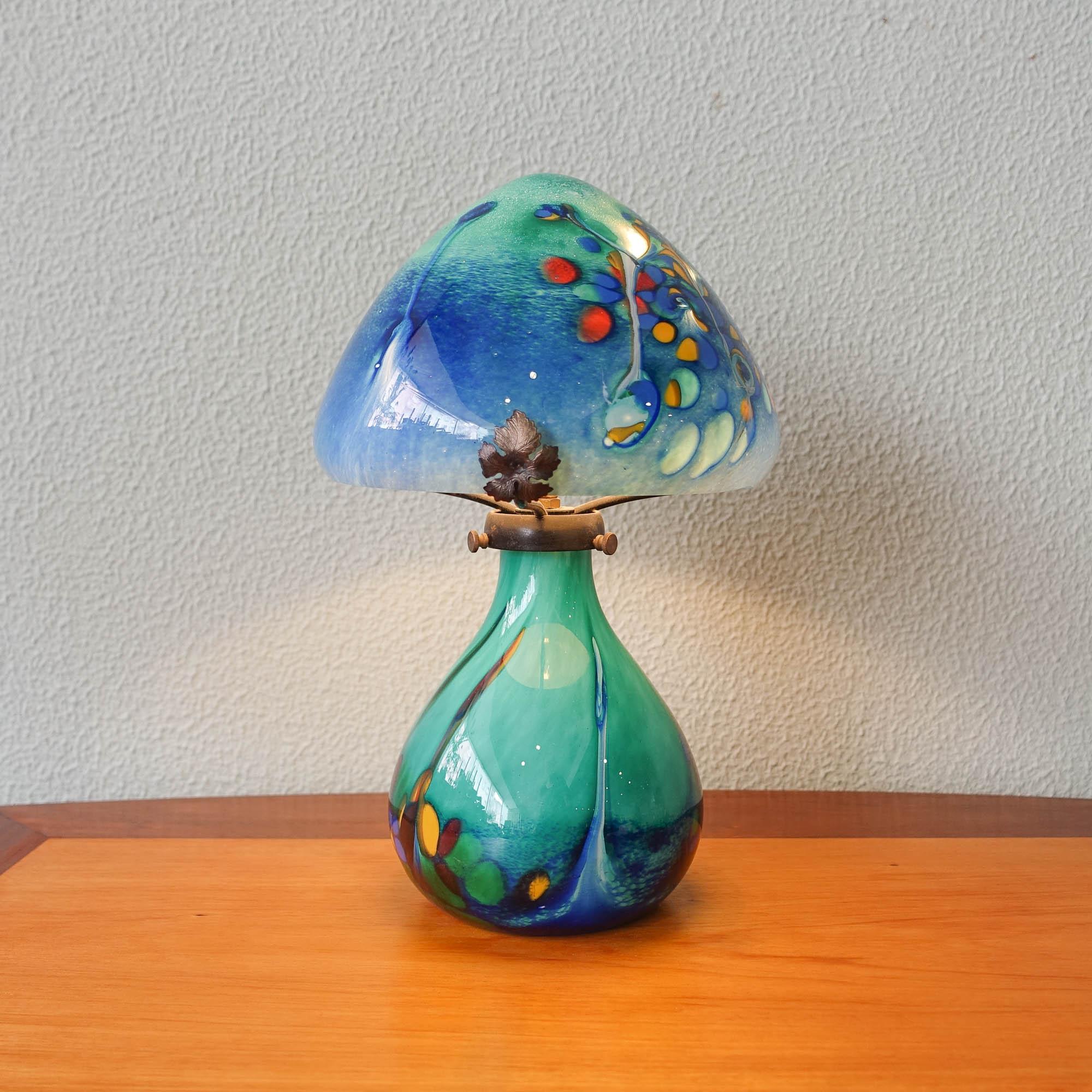 This Art Nouveau Style table lamp was designed and manufactured in France, during 1970's. The base and the lampshade are both in color blown glass and has brass flowers details.
 It is in original and good vintage condition.