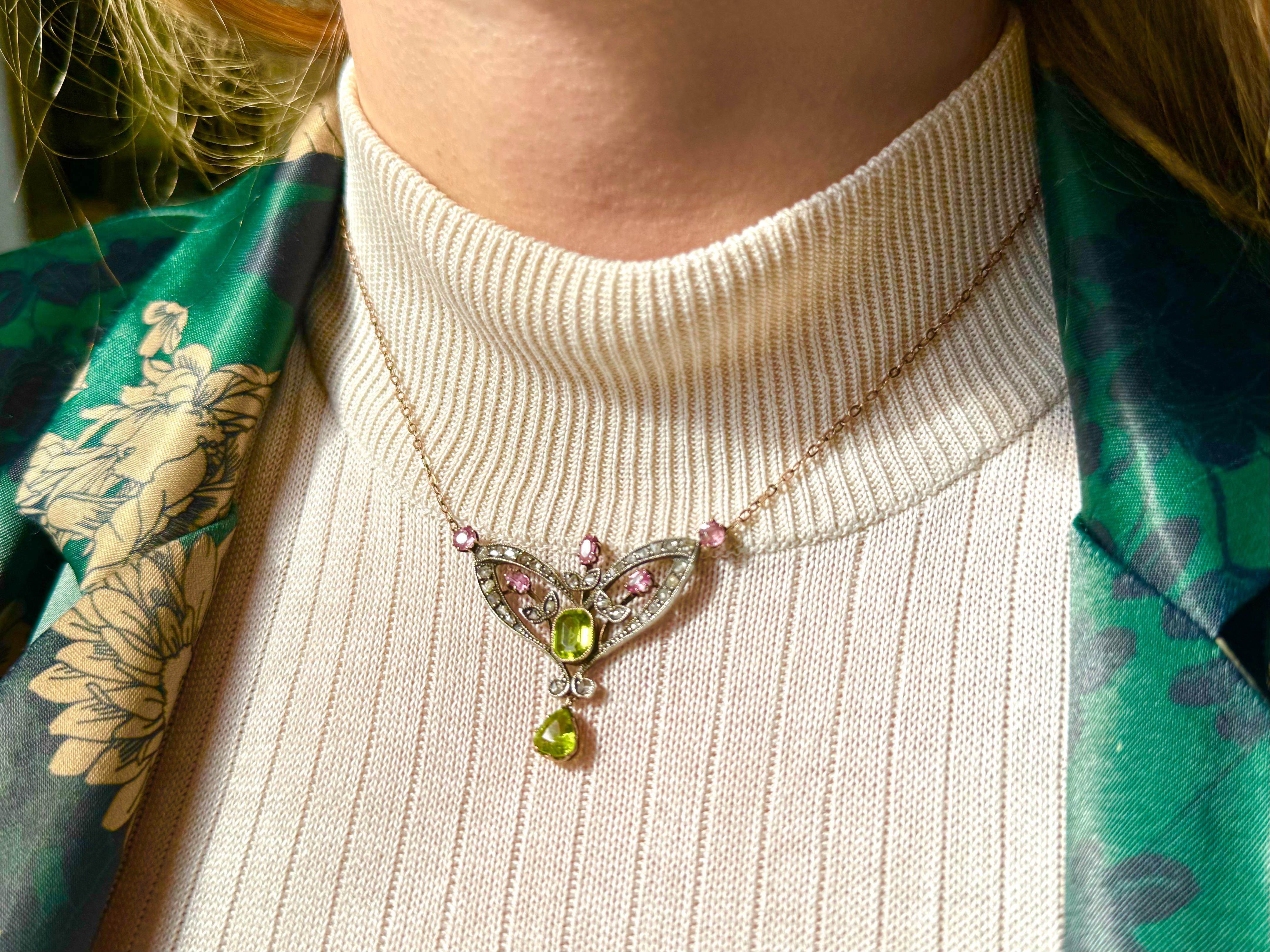 A unique necklace in the Art Nouveau style with a sophisticated form, characteristic of this era. The necklace is set with old-cut diamonds, 5 pink tourmalines and two beautiful green peridots. The choice of stone colors is not accidental here and