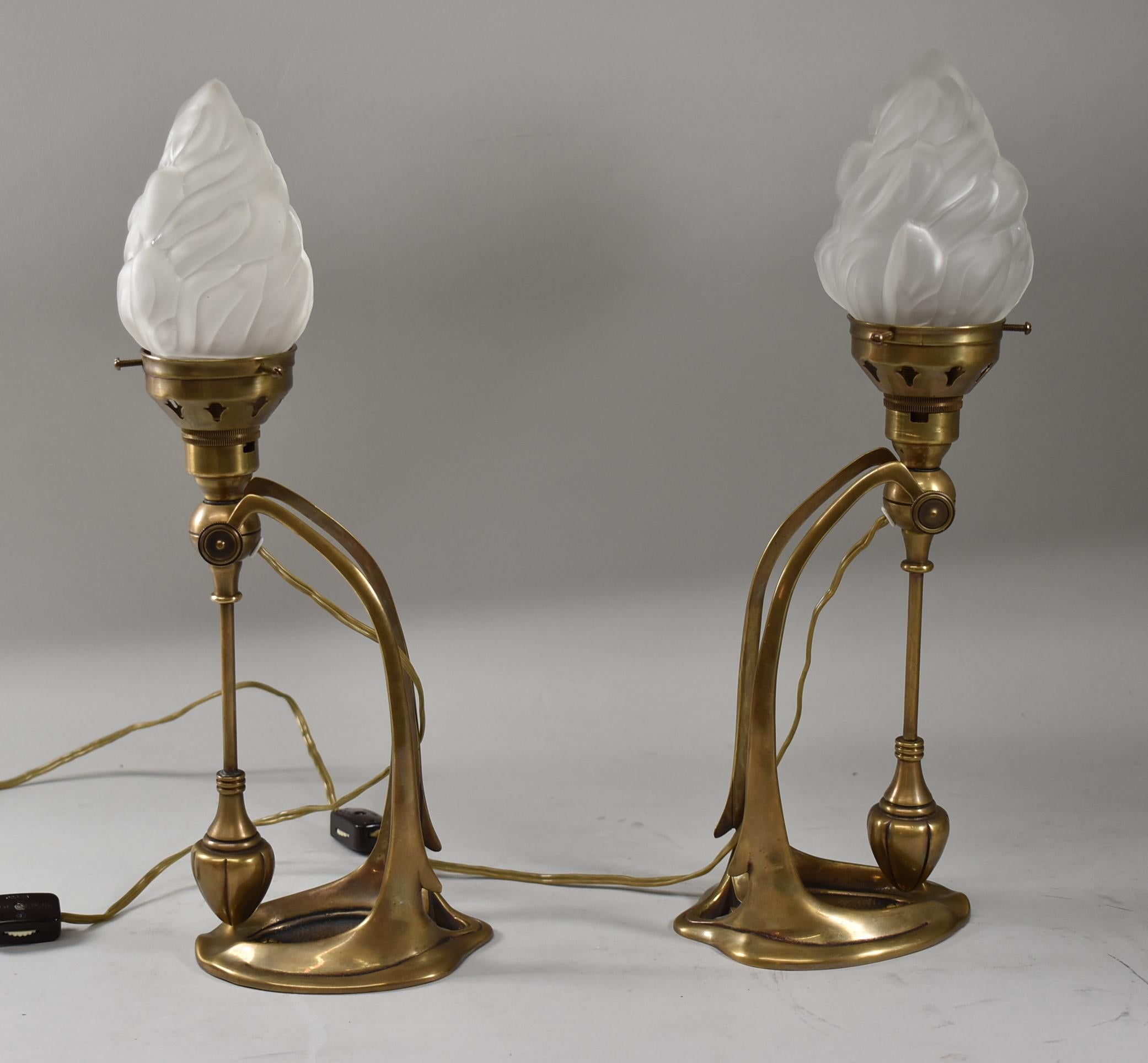 Pair of Art Nouveau style bronze mantle lamps with vintage opaque flame shape glass shades. Measures: 10.5
