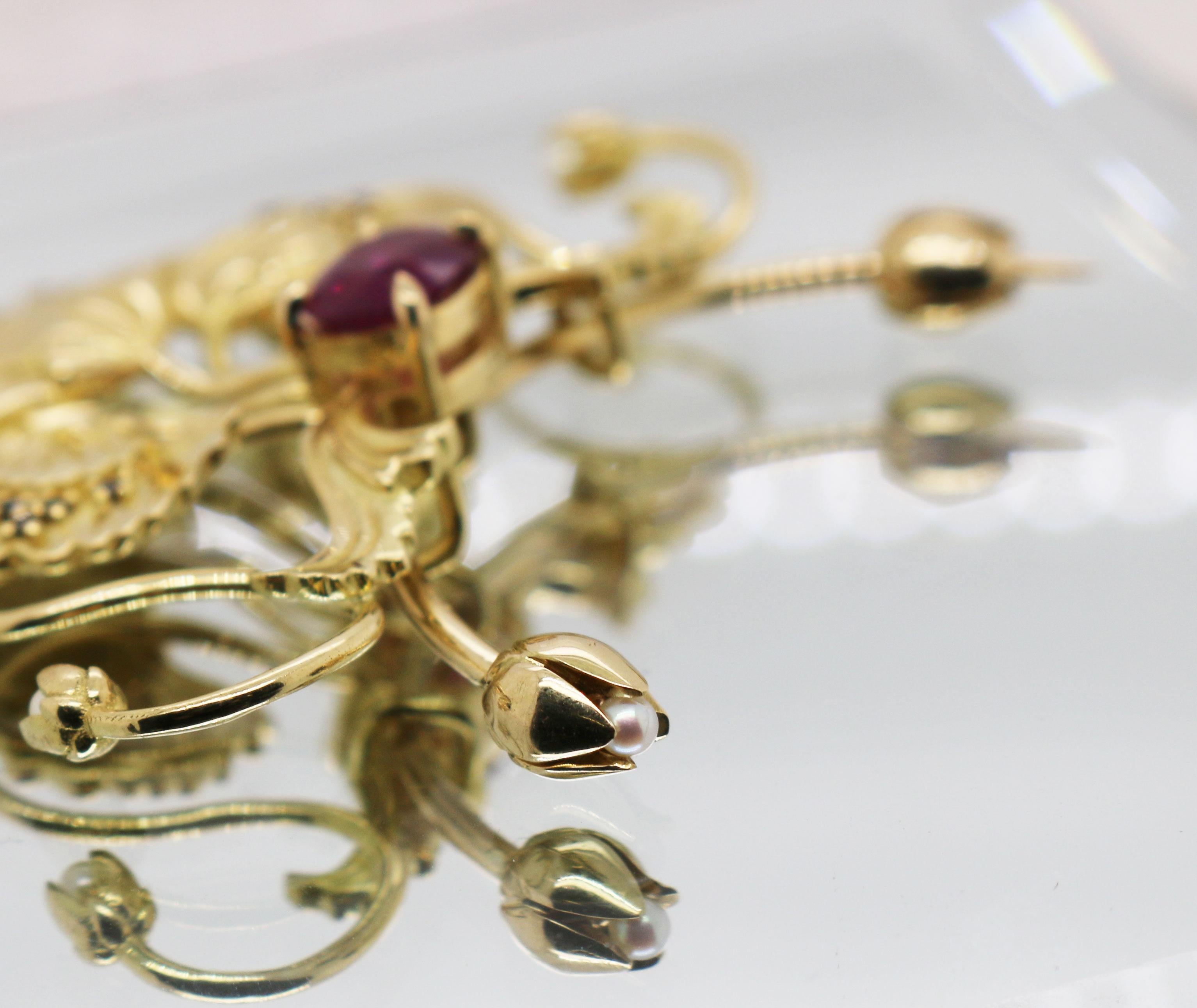 Pendente a forma di papavero in stile Art Nouveau con rubino, diamanti neri e perle. 

L'attacco della spilla scorre attraverso la sezione del ciondolo e presenta due boccioli di fiori.

Realizzato su ordinazione. 

Oro giallo 18ct

Invia un