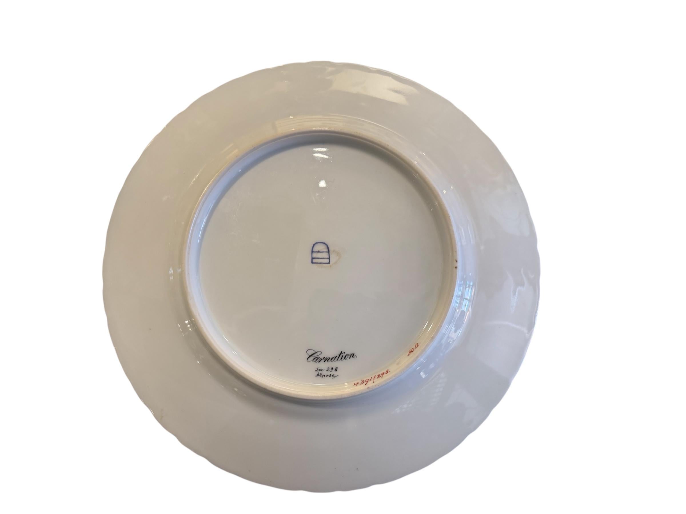 This is an Art Nouveau Royal Vienna Porcelain Portrait Plate. It depicts a round porcelain plate hand painted royal and light blue in its background. At the center of the plate there is a portrait of a beautiful young woman with long undulated brown