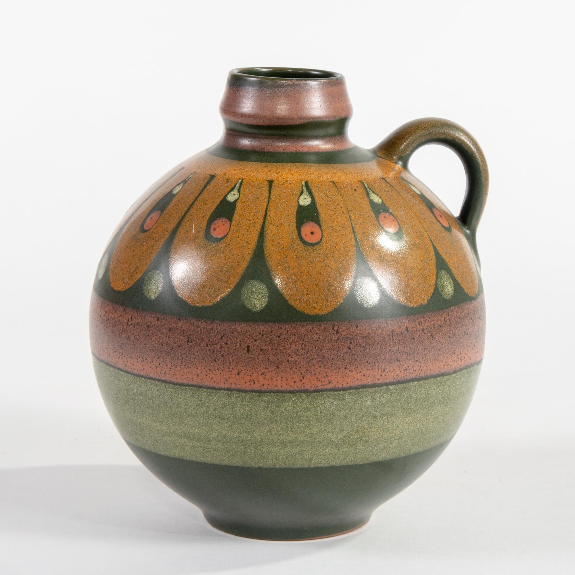 Round jug attributed to Elchinger with glaze in muted green bands and orange-gold looped band at top, circa 1930s. Very good vintage condition with no flaws found.