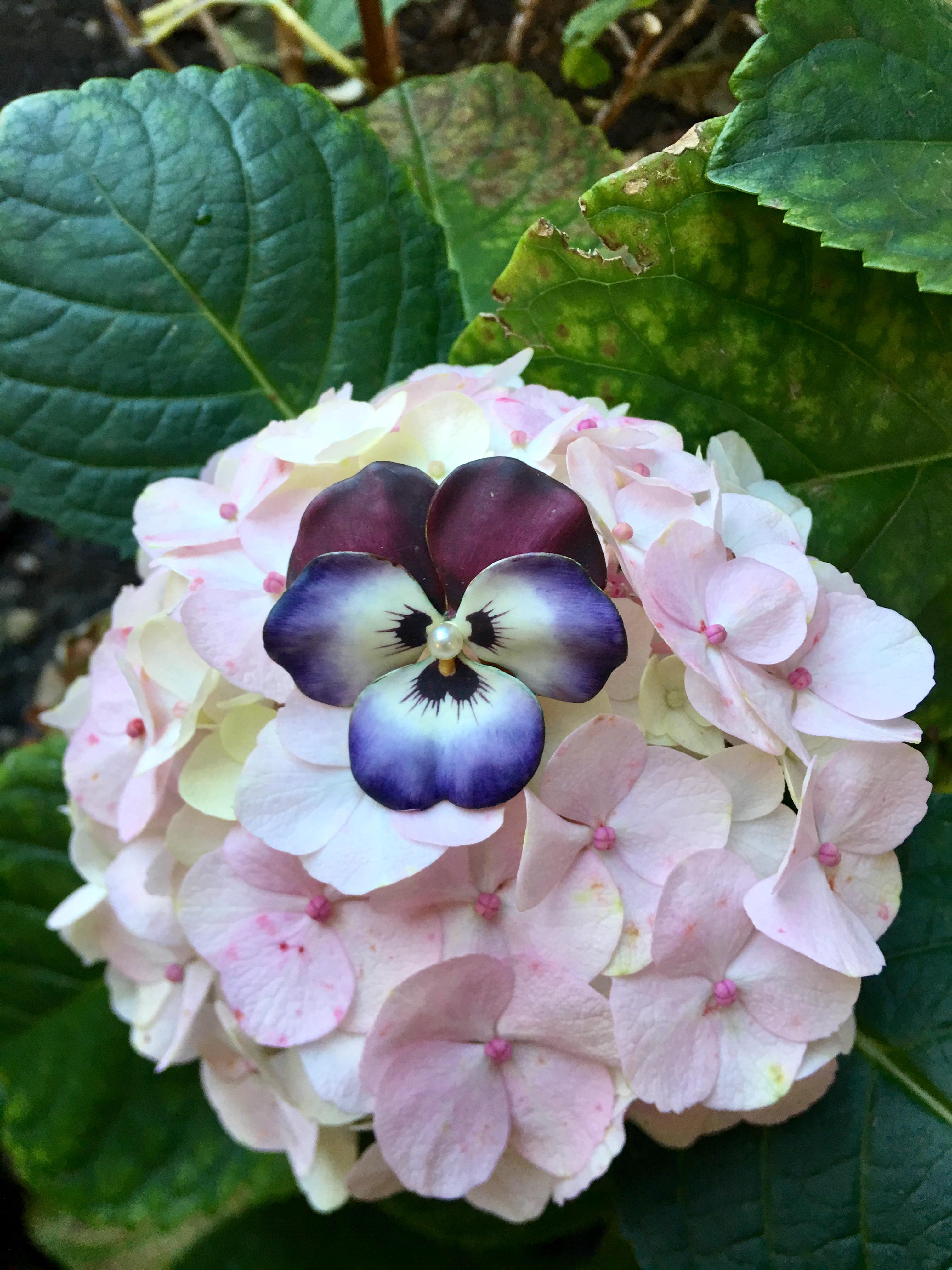 Beautifully handmade and hand painted, vintage, estate, 14 karat yellow gold and enamel purple pansy pin or brooch features a white pearl center, surrounded by five realistically sized, shaped and painted enamel pansy flower petals in shades of