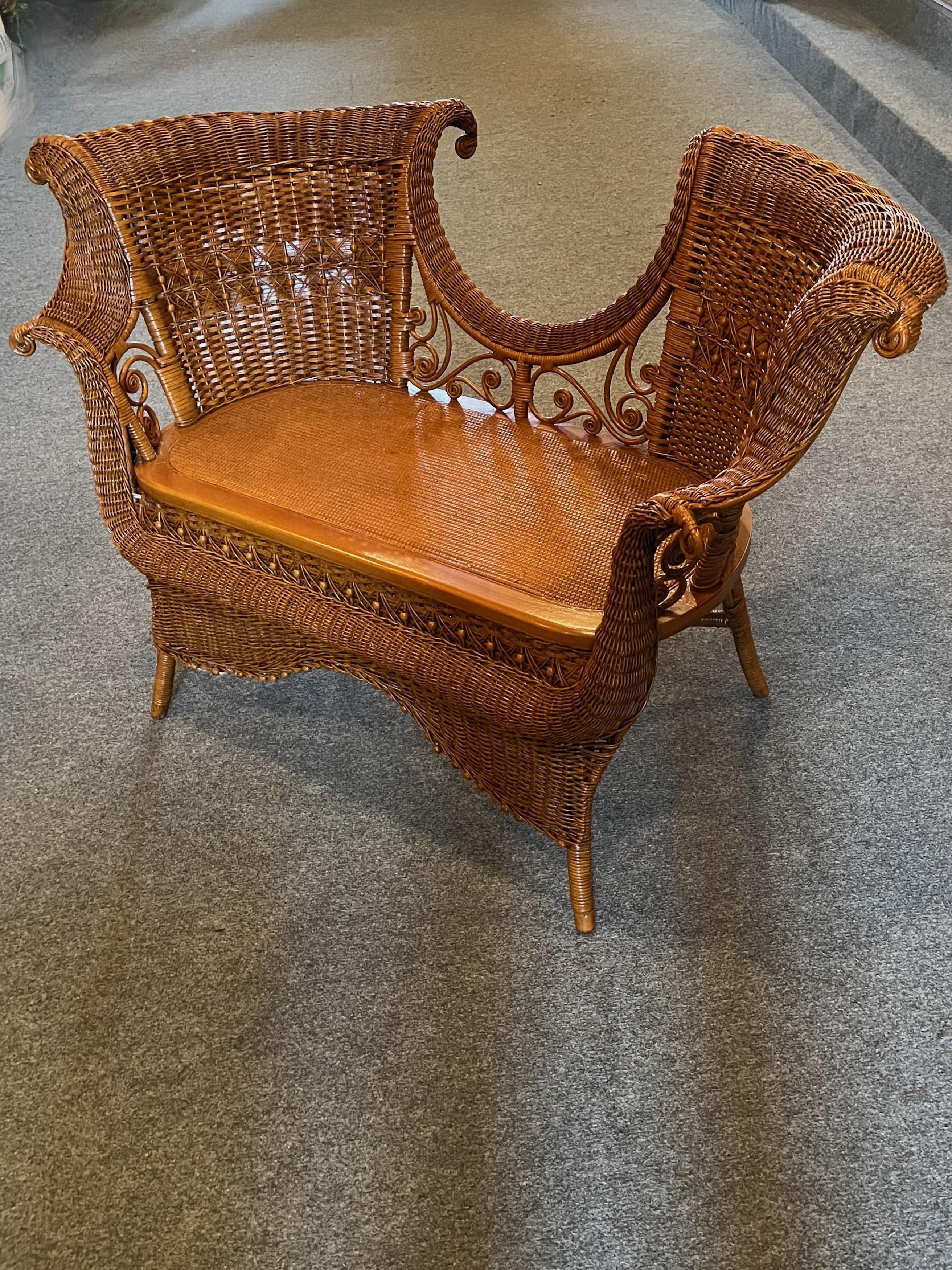 A rare early wicker settee also known as a Tete-Tete that is attributed to the Wakefield Rattan Company of Wakefield, Massachusetts. It was designed in the late 19th C. and is done in a beautiful all natural finish. This is a very rare piece of