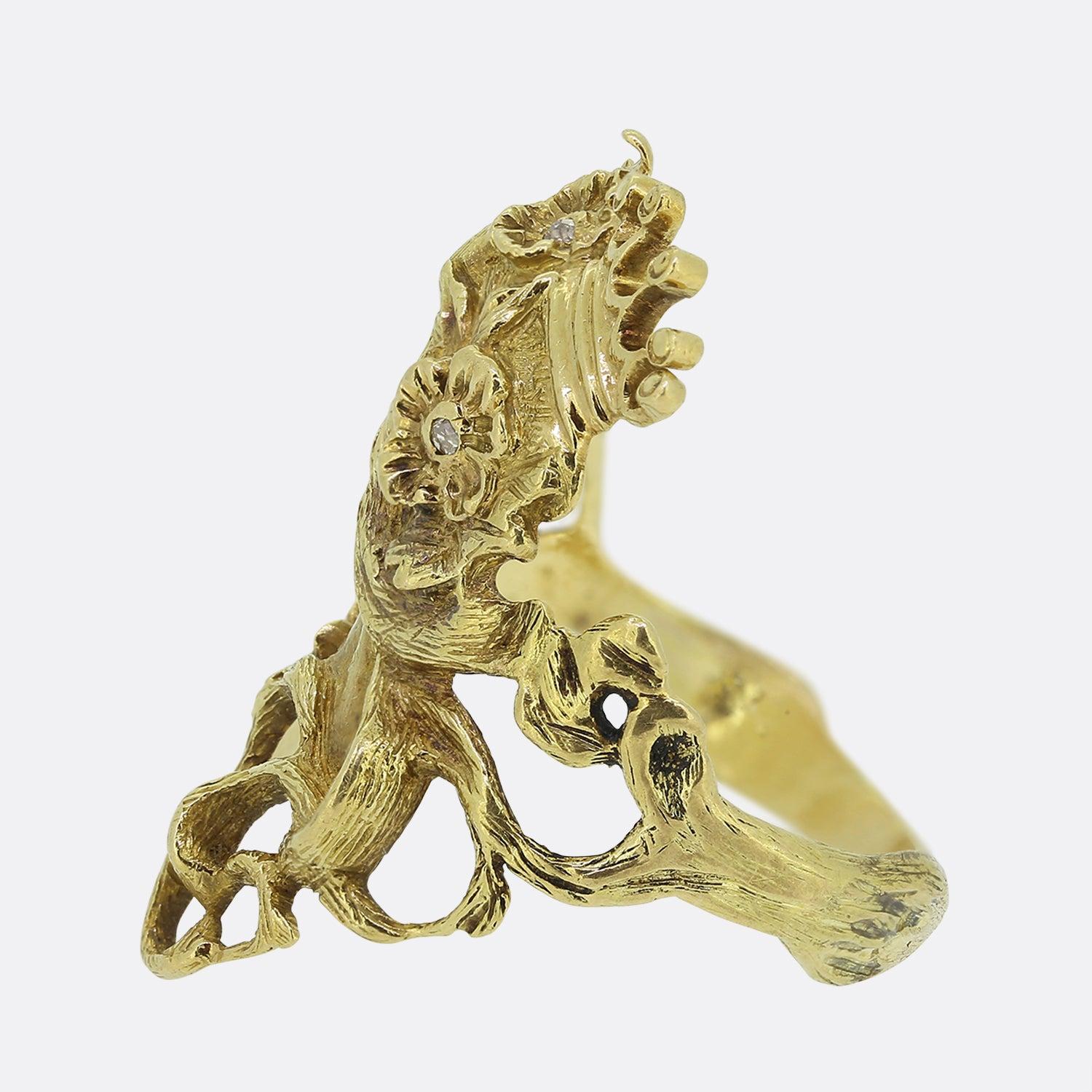 Here we have an excellently crafted 14ct yellow gold ring. This piece is characterised by a stylised female profile featuring sculptural, flowing locks and intricately engraved florals. Three single cut white diamonds punctuate the centre of each