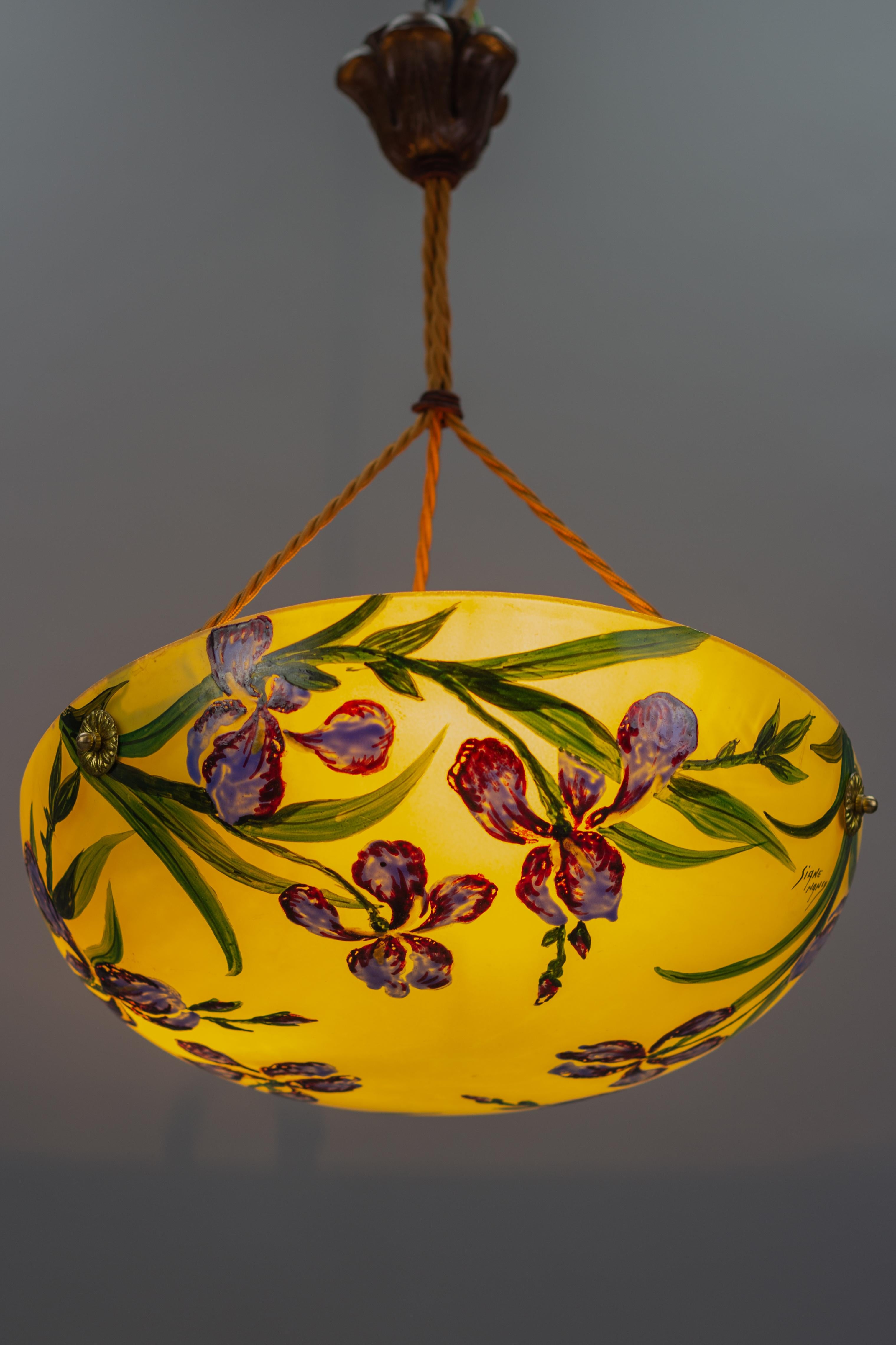 This beautiful French Art Nouveau style pendant ceiling light features a yellow glass shade with hand-painted blue iris flowers, signed 