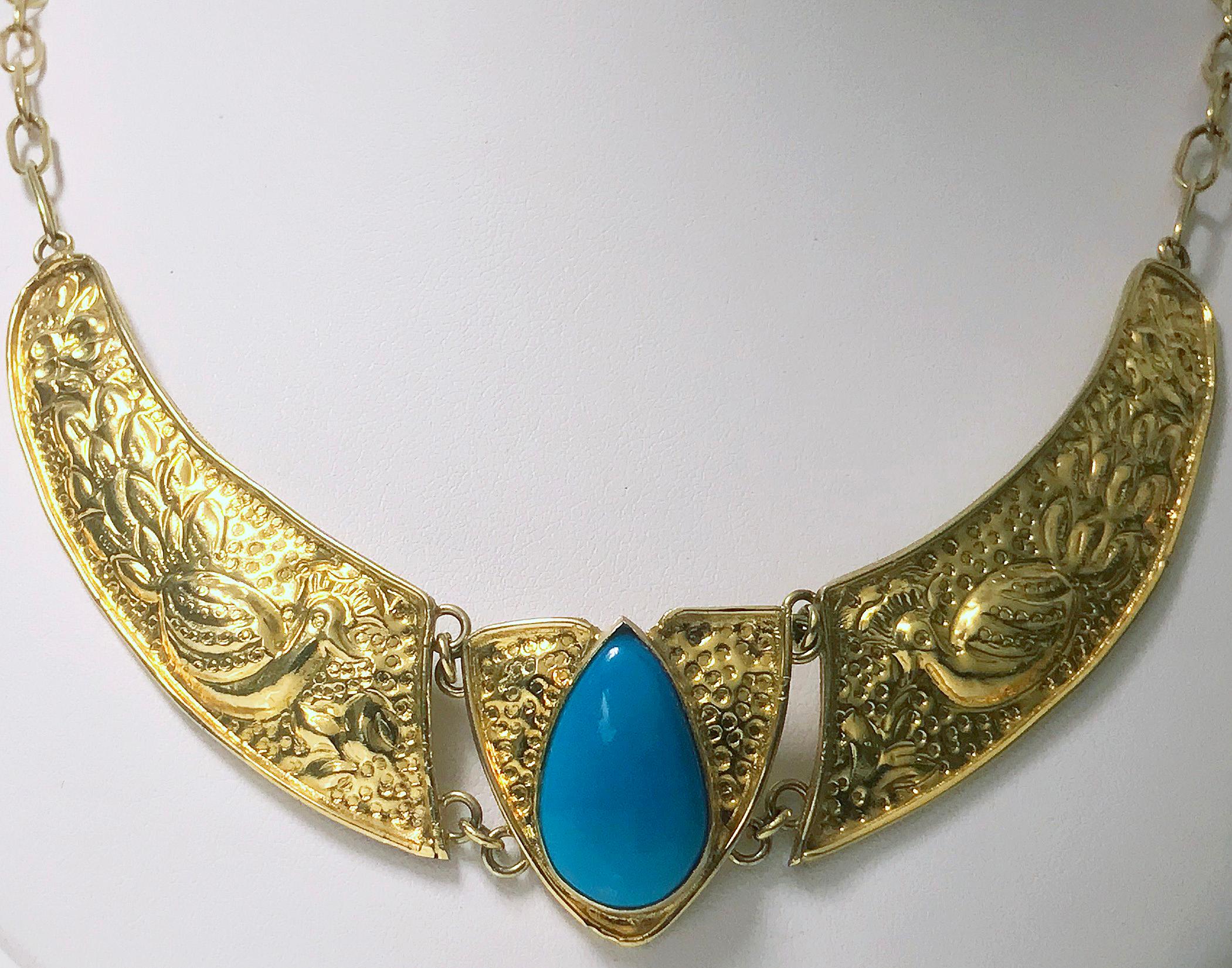 Art Nouveau style yellow Gold and Turquoise Necklace, last quarter of 20th century. The Necklace with three linked sections depicting peacocks on stippled background on either side of a bezel set pear shaped cabochon turquoise in gold stippled