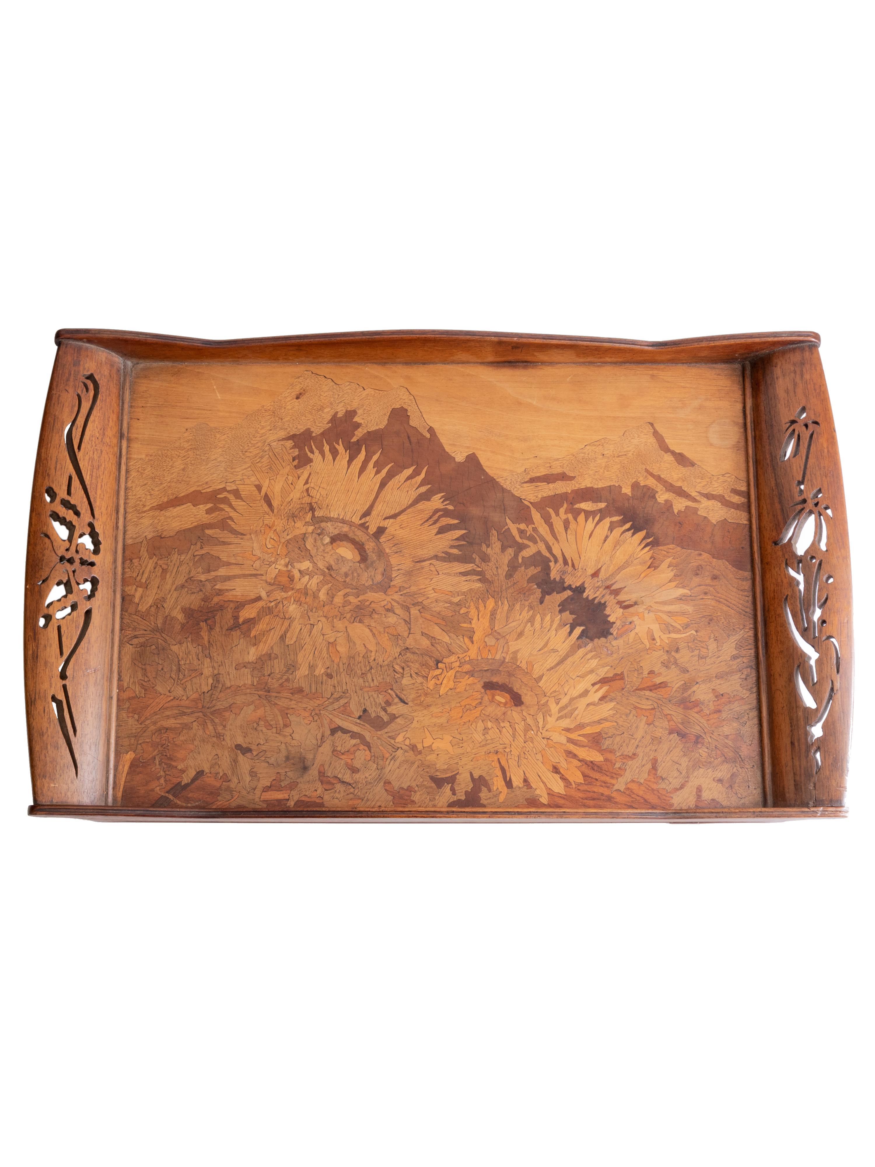This Art Nouveau marquetry tray is a masterful creation by Émile Gallé (1846–1904), one of the most prominent figures of the École de Nancy. 
Crafted in the early 20th century, this rectangular tray showcases finely inlaid sunflowers set against a
