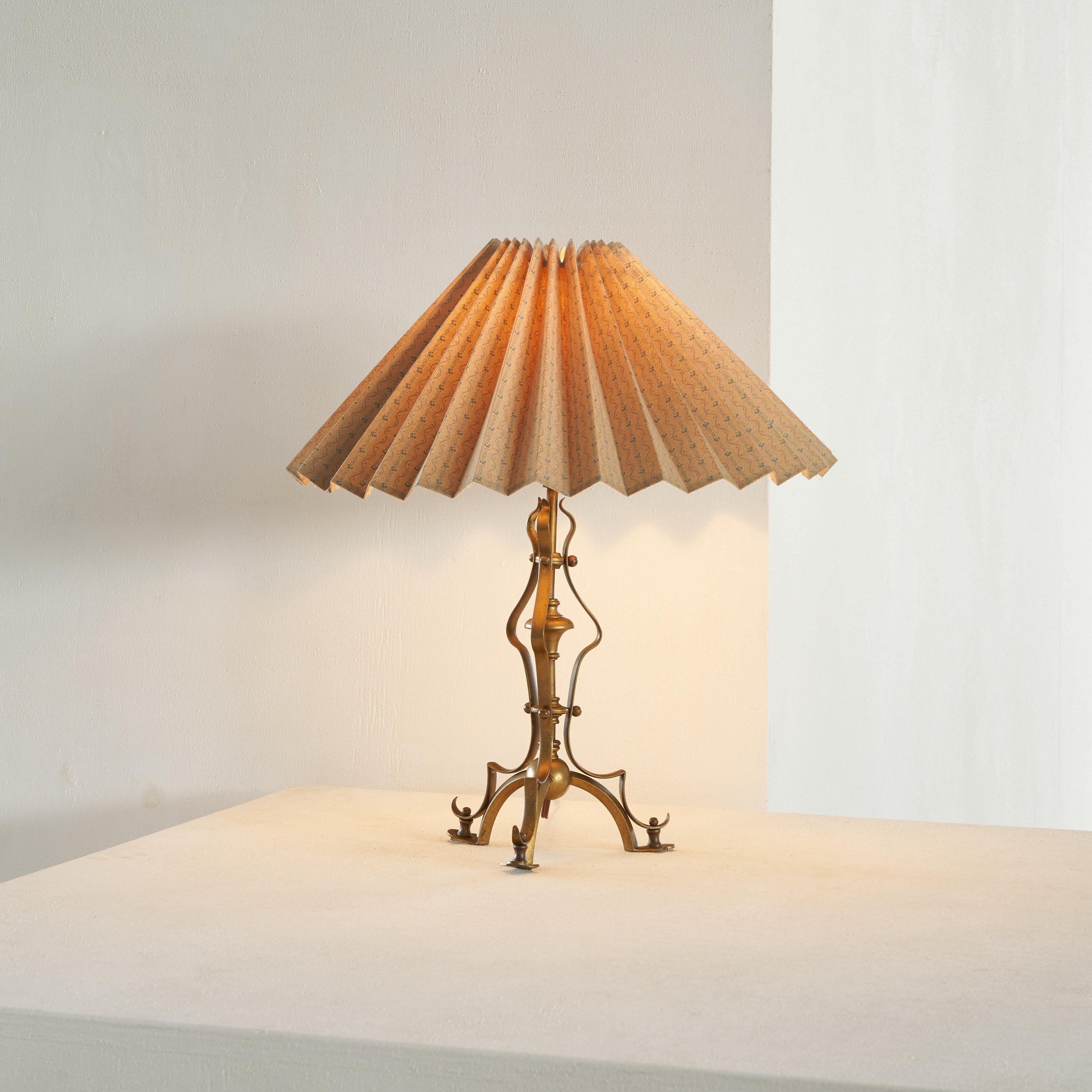Art Nouveau table lamp in Patinated Brass with Plissé Shade. Early 20th century.

Wonderful art nouveau table lamp with an unusual design. This table lamp in patinated brass is very art nouveau with its curvy and floral shapes and sharp edges. A
