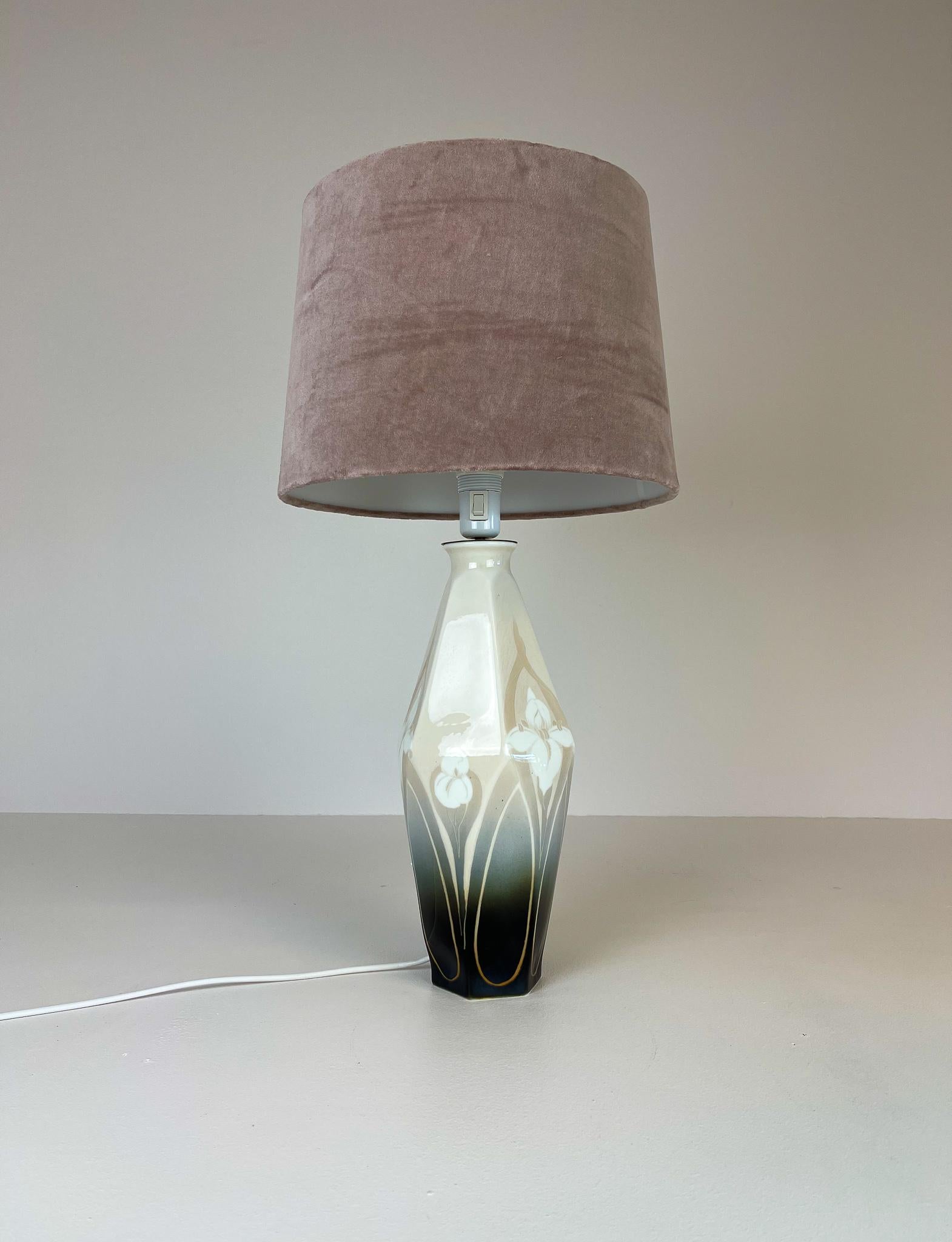 This rare table lamp was made in the begging at 1900. Made at Rörstrand factory and designed by Astrid Ewerlöf. The lamp has a wonderful shaped body with the typical Art Nouveau flowers. New shade in velvet. 

Good condition, rewired.

Measures: