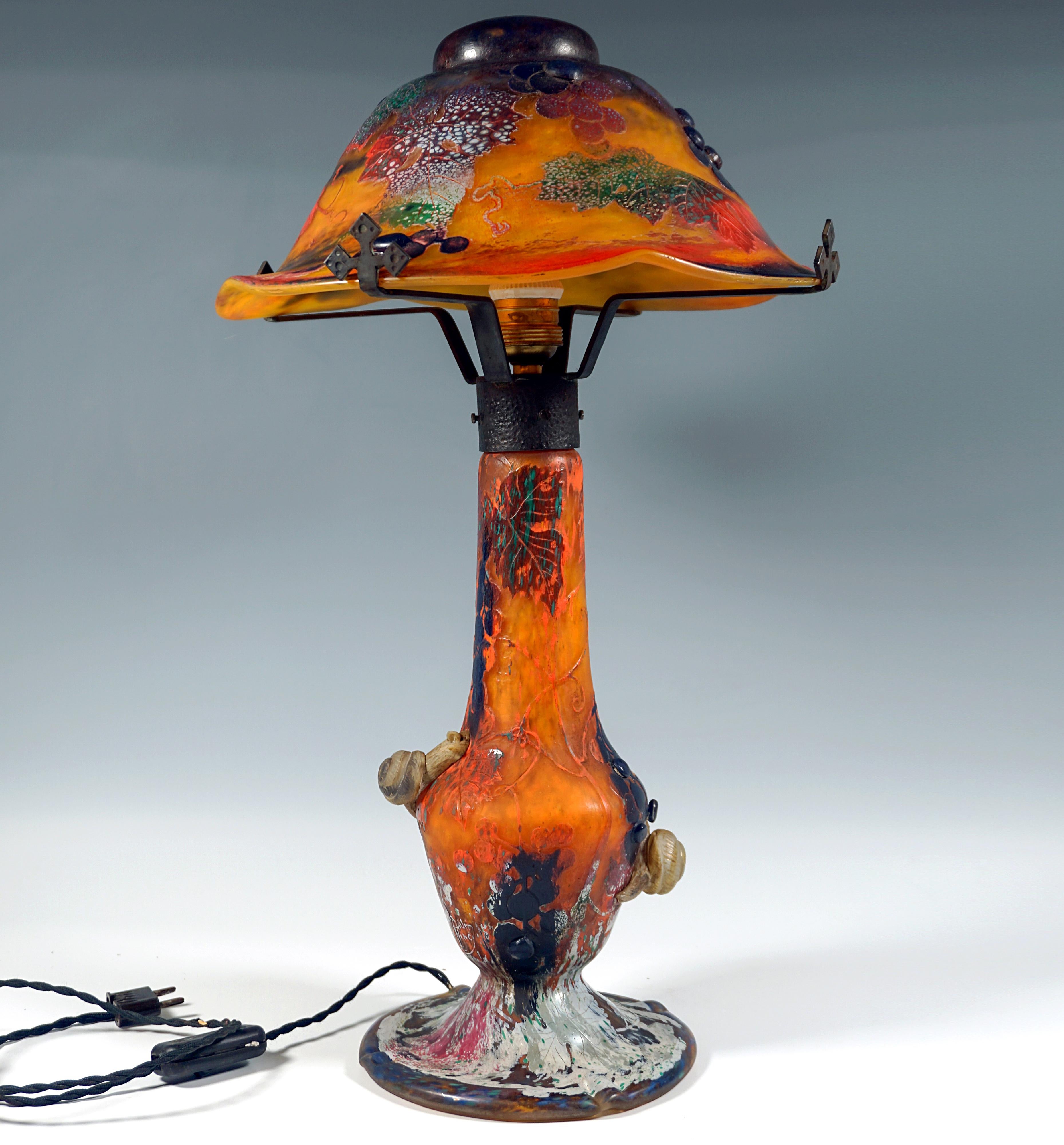 Un pezzo da museo dell'arte vetraria francese Art Nouveau:
Lampada con piede a forma di balaustro su un supporto rotondo e piatto a gradini sollevato al centro, paralume emisferico, leggermente stirato a caldo e pressato verso l'alto su quattro