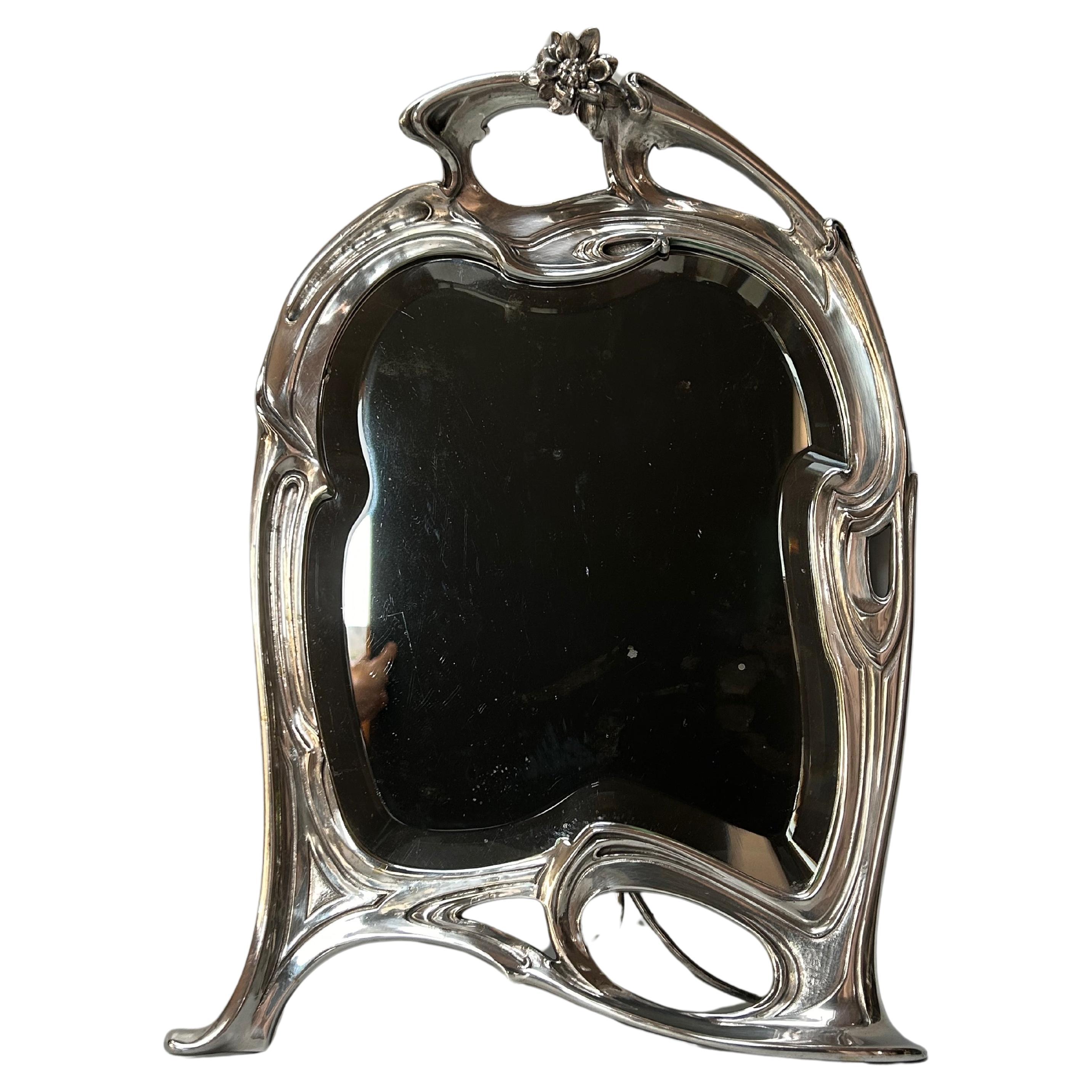 Art Nouveau silvered bronze mirror circa 1900.
In very good condition.
No trace of stamping or marking.
This mirror is authentic.
A few small stains on the mirror should be noted.

Height: 46.5 cm
Width: 32 cm
Depth unfolded: 21 cm
Weight: 4 Kg