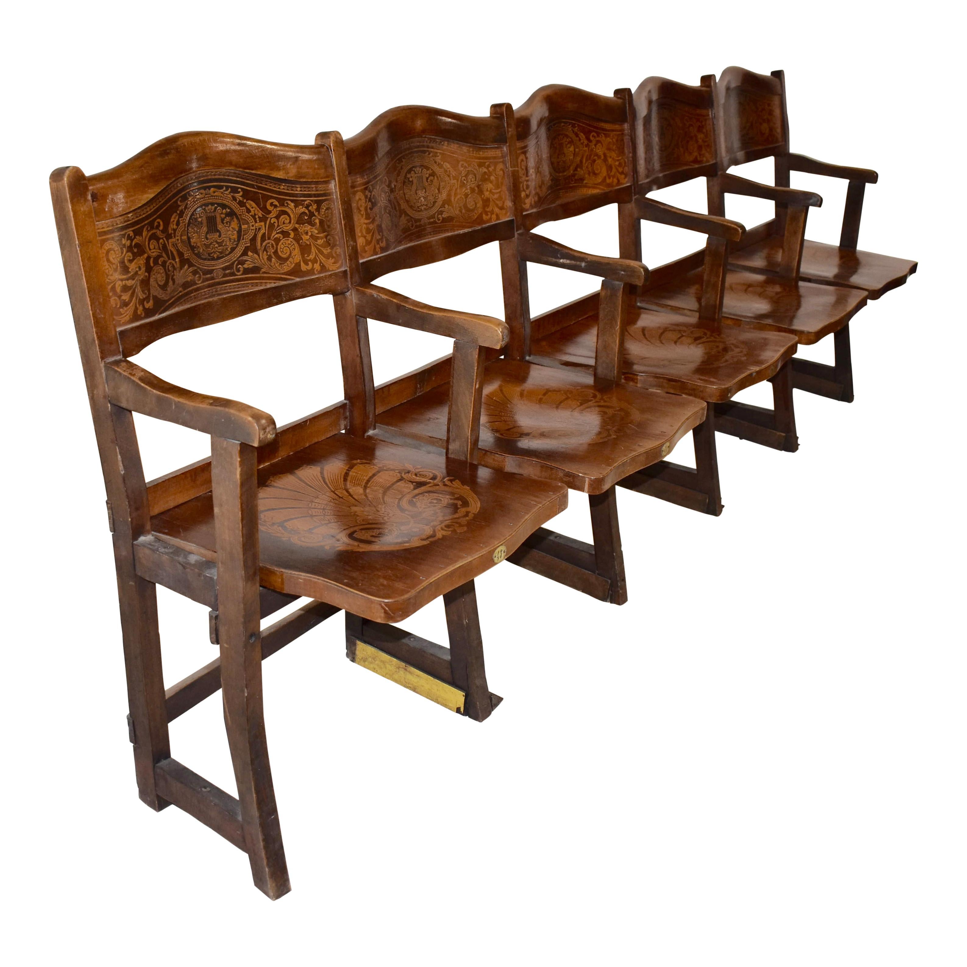 The rosewood and maple marquetry in the back rests and seats of this row of theatre seats from Belgium is exquisite. All five flip-down seats are back waited, which brings the seats to their upright position. We have seen many wood theatre seats in