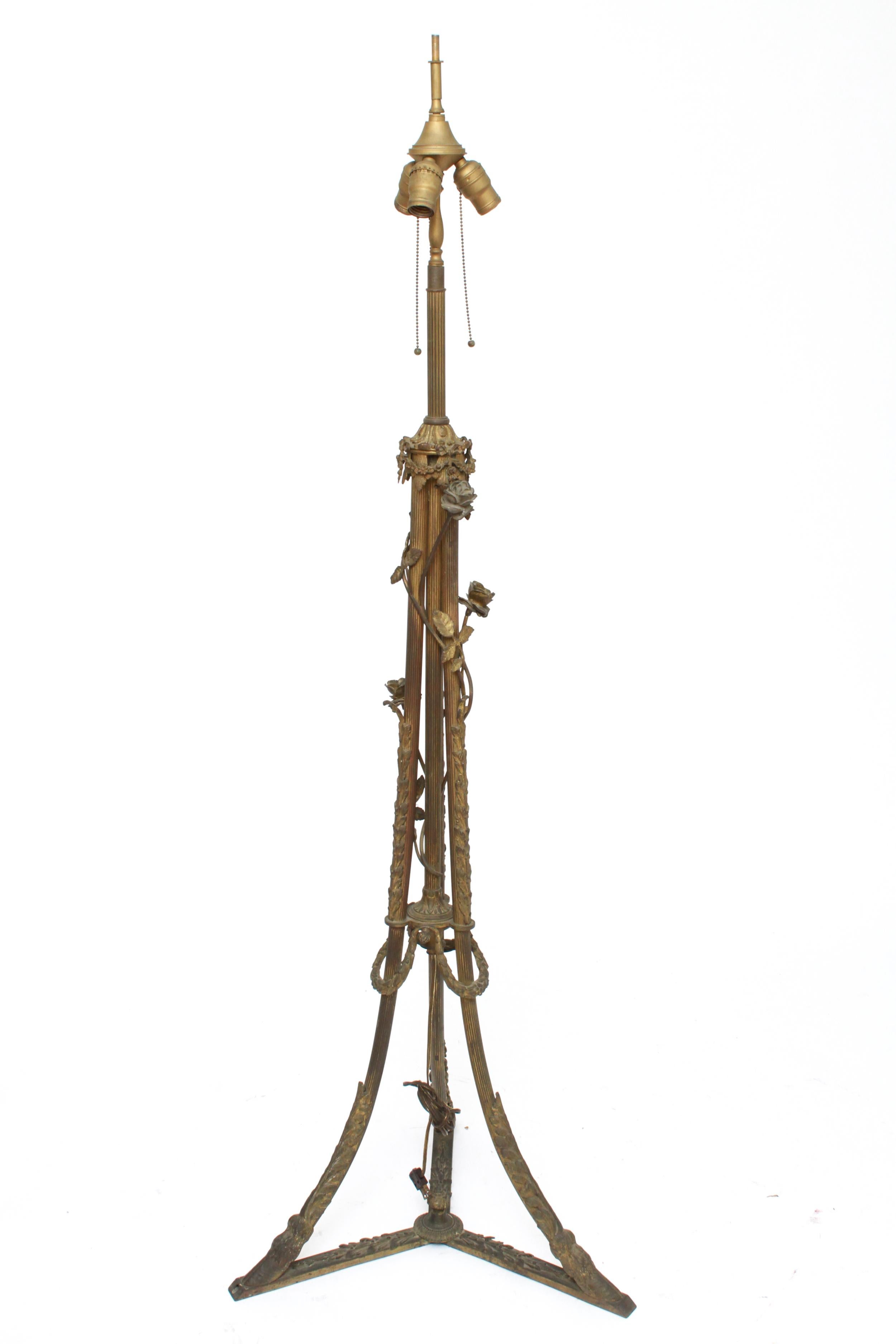 American Art Nouveau Tiffany style slag or marble glass floor lamp with a shade decorated with a floral motif atop a Neoclassical manner tripod base with floral and vine motif and hoof feet. The piece is in great vintage condition with