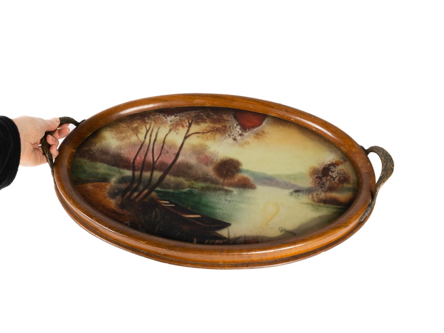 An Art Nouveau oval tray signed by Germonde with a pyrographic landscape etched in the bottom with metal handles.
An old butlers tray for a cocktail party.

Width 20,47 in (52 cm) 
Depth 13,77 in (35 cm)
Height: 1,26 in (3,2 cm)
Handle height: 2,36
