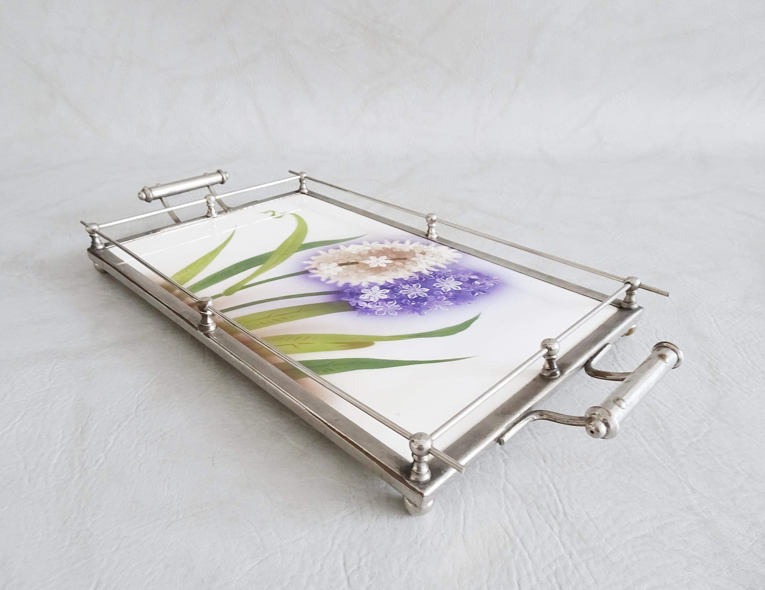 Stylish tray Art Nouveau. The serving tray has a ceramic surface with a floral spray decor. A timeless motif, in natural colors. nickel plated metal frame with ball holders and elegant handles on four ball feet.

A rare and decorative home decor