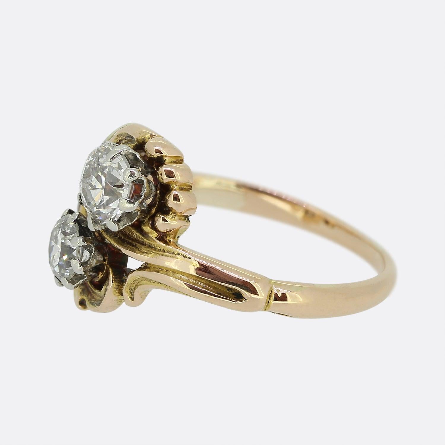 Here we have a delightful 18ct yellow gold ring crafted at a time when the Art Nouveau style was at the height of design. A duo of old European cut diamonds sit individually claw set in a diagonal formation atop a rich swirling backdrop; the