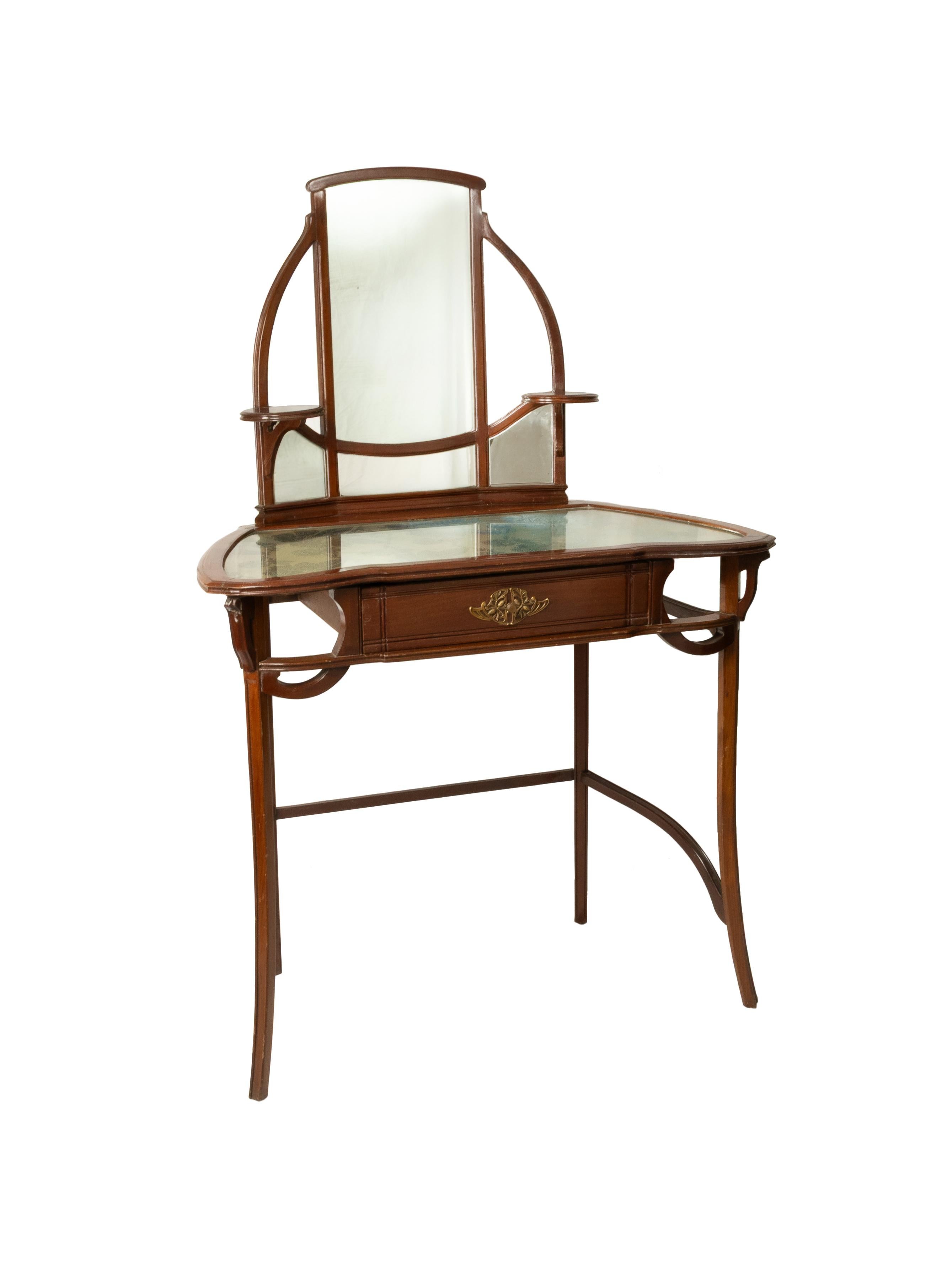 Una toletta in legno di ciliegio degli anni '20, un esempio dell'eleganza dell'Art Nouveau.

Oggetto di design francese con specchio e vetro intarsiato che protegge un tessuto con motivi vegetali in verde. 
La toeletta ha un cassetto

Questo pezzo