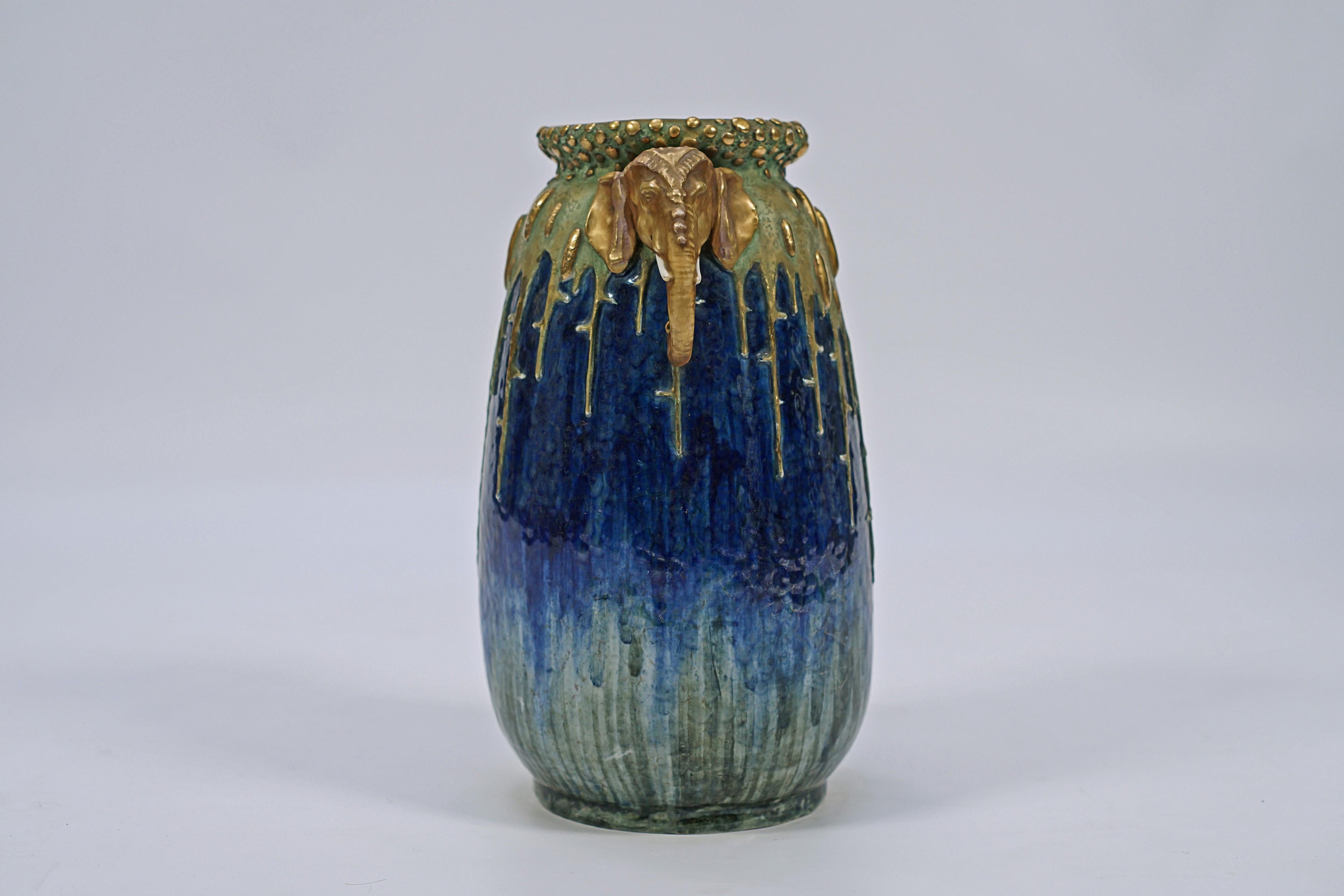 Vase Art nouveau en porcelaine émaillée bleue et verte, avec des détails dorés et des anses à motif de tête d'éléphant, fabriqué par AMPHORA. Sceau de la couronne signé, AMPHORA, Autriche, n° 2191, n° 56.

Autriche, vers 1900.