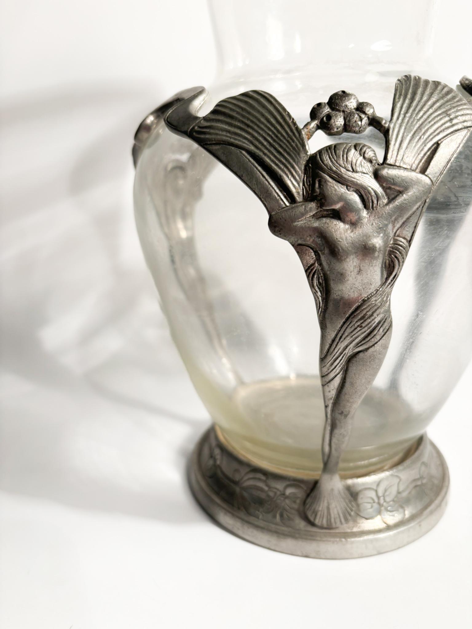 Liberty-Vase aus transparentem Glas und Zinn mit geschnitzten Damen, aus dem frühen 20. Jahrhundert

Ø cm 16 h cm 28

Der Jugendstil ist ein internationaler Stil der Kunst, Architektur und angewandten Kunst, insbesondere der dekorativen Künste, der