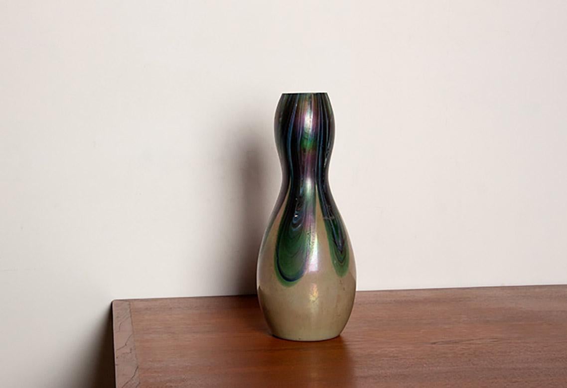 Grazioso vaso in stile Art Nouveau. Decorazione verde iridescente con forme di piume di pavone. Tipico oggetto d'arte Favril ispirato alle creazioni di Tiffany. Oggetto raffinato ed elegante in perfette condizioni. Un'etichetta, staccata, sotto il