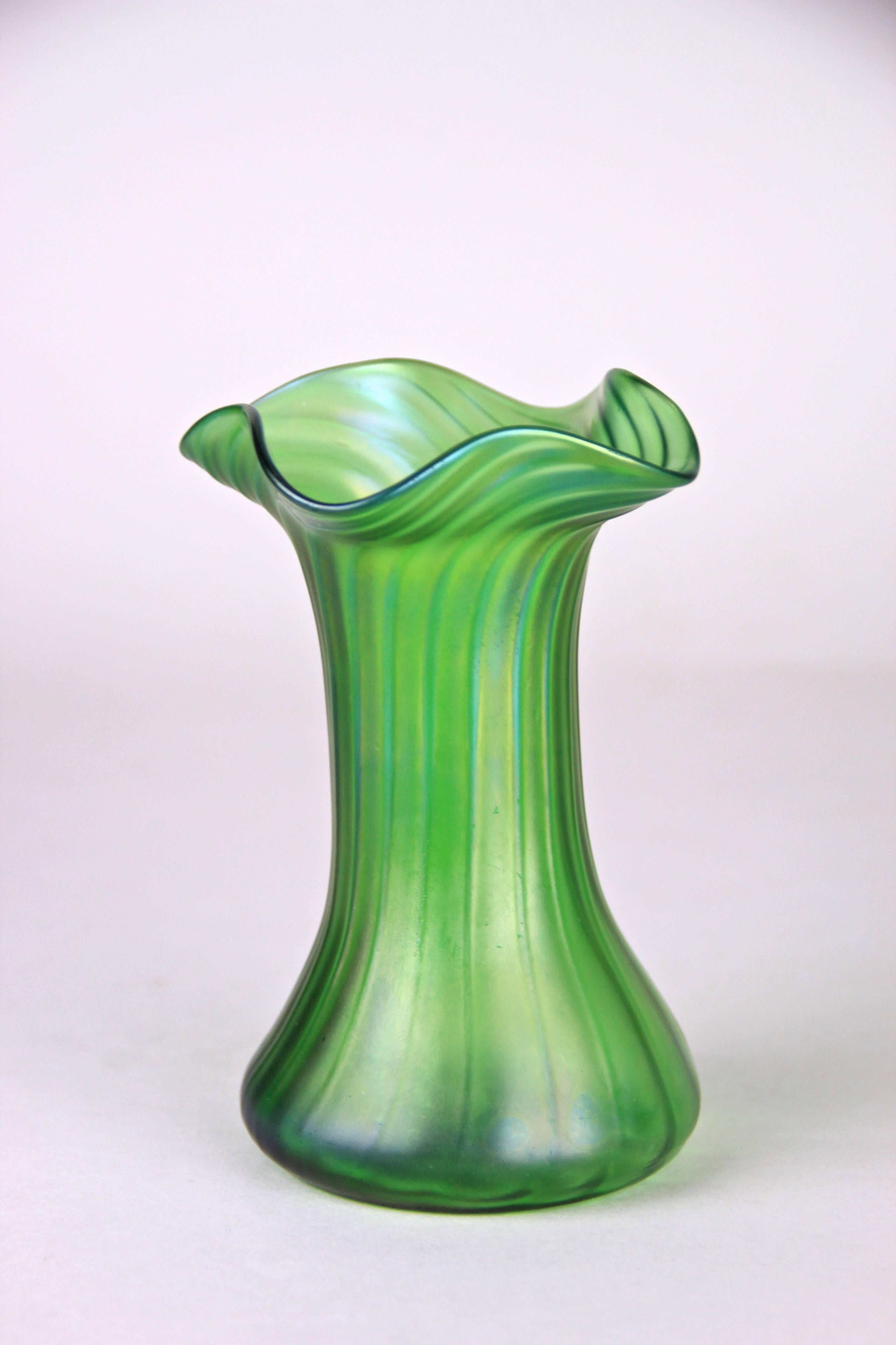 This lightly iridescent small Art Nouveau vase comes out of the famous Bohemian glass manufacture of Kralik. The iridescent design, well-known from other famous companies like for example Loetz Witwe, shimmers in beautiful colors from purple,