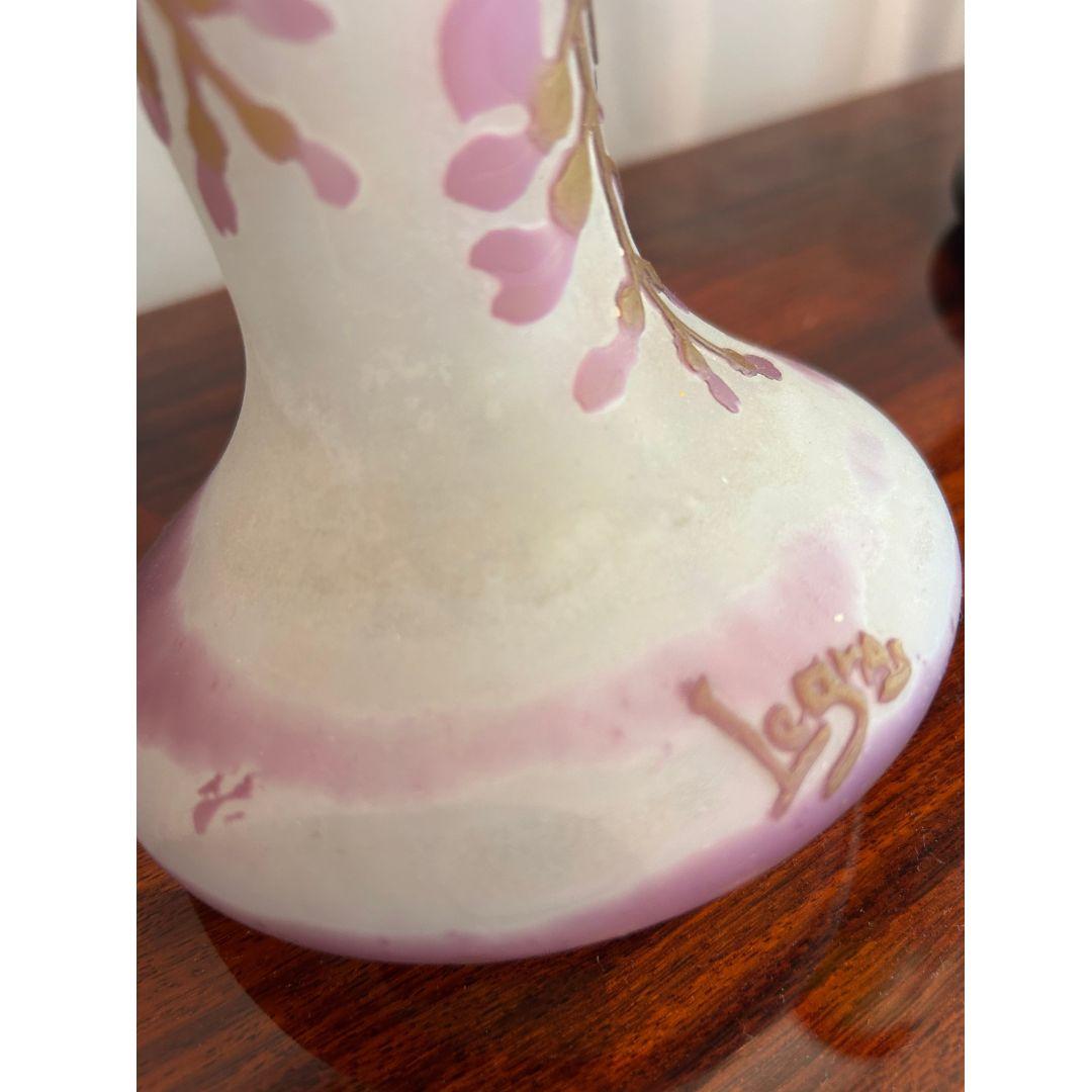 I vasi Legras, risalenti al 1900 circa, sono caratterizzati da vetro bianco sovrapposto a viola e verde, inciso con delicati motivi di glicine. Firmati dal rinomato vetraio francese Legras, questi vasi, alti 47 cm, esemplificano lo stile Art Nouveau