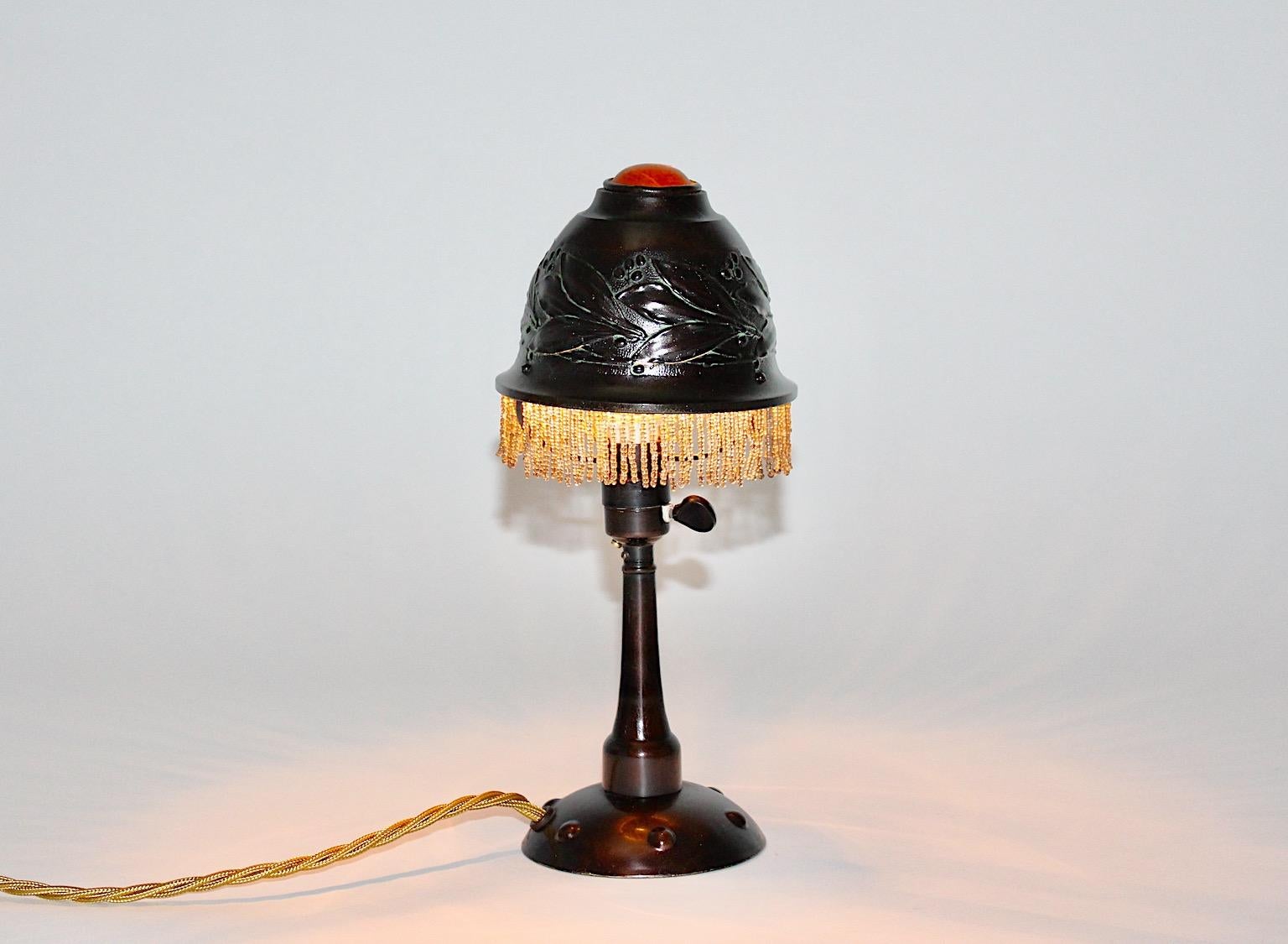 Lámpara de mesa o mesilla de noche Art Nouveau vintage de metal bruñido con una piedra decorativa de color naranja ámbar hacia 1910 Francia.
Maravillosa lámpara de sobremesa o de mesilla de noche de metal bruñido con una hermosa pantalla, que