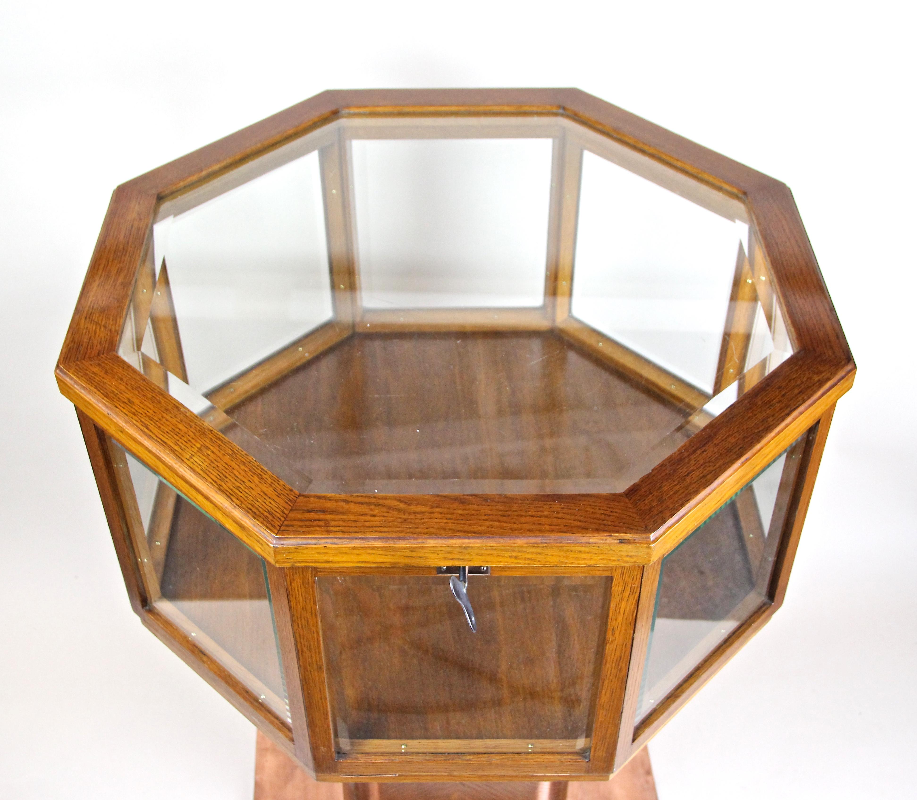 Extraordinary Art Nouveau vitrine table or display table from the early period in Austria, circa 1900. The great designed oakwood vitrine table shows an octagonal shaped upper part, still holding the original facet cut glass panels. Sitting on a