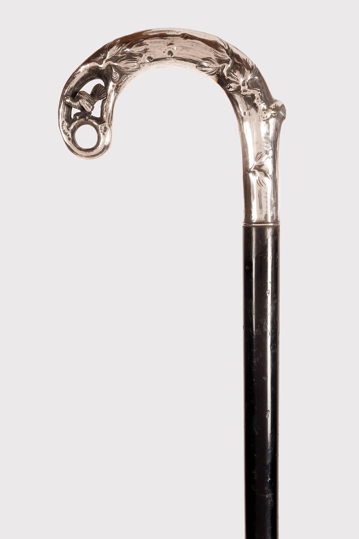 Bastón: pomo de plata liberty, representa la danza de un urogallo enamorado, en el fondo ramas de roble, con hojas y bellotas. Barril de madera de ébano. Punta metálica de latón y hierro. Viena, Austria, hacia 1900.