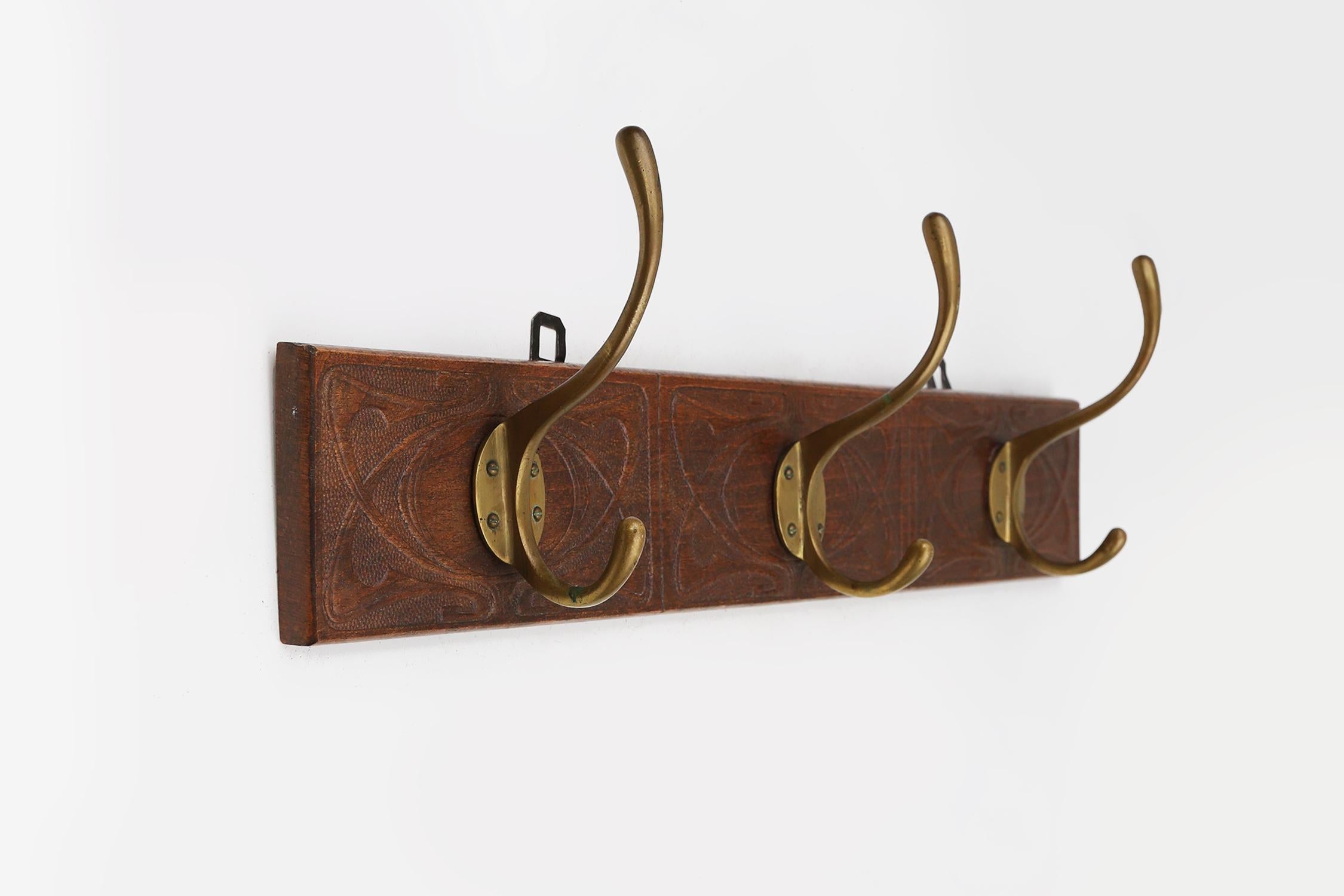 French Art Nouveau wall coat rack in carved wood with brass, France ca. 1910 For Sale