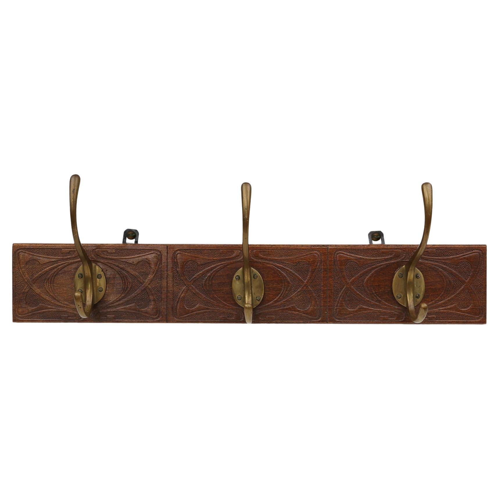 Art Nouveau wall coat rack in carved wood with brass, France ca. 1910 For Sale