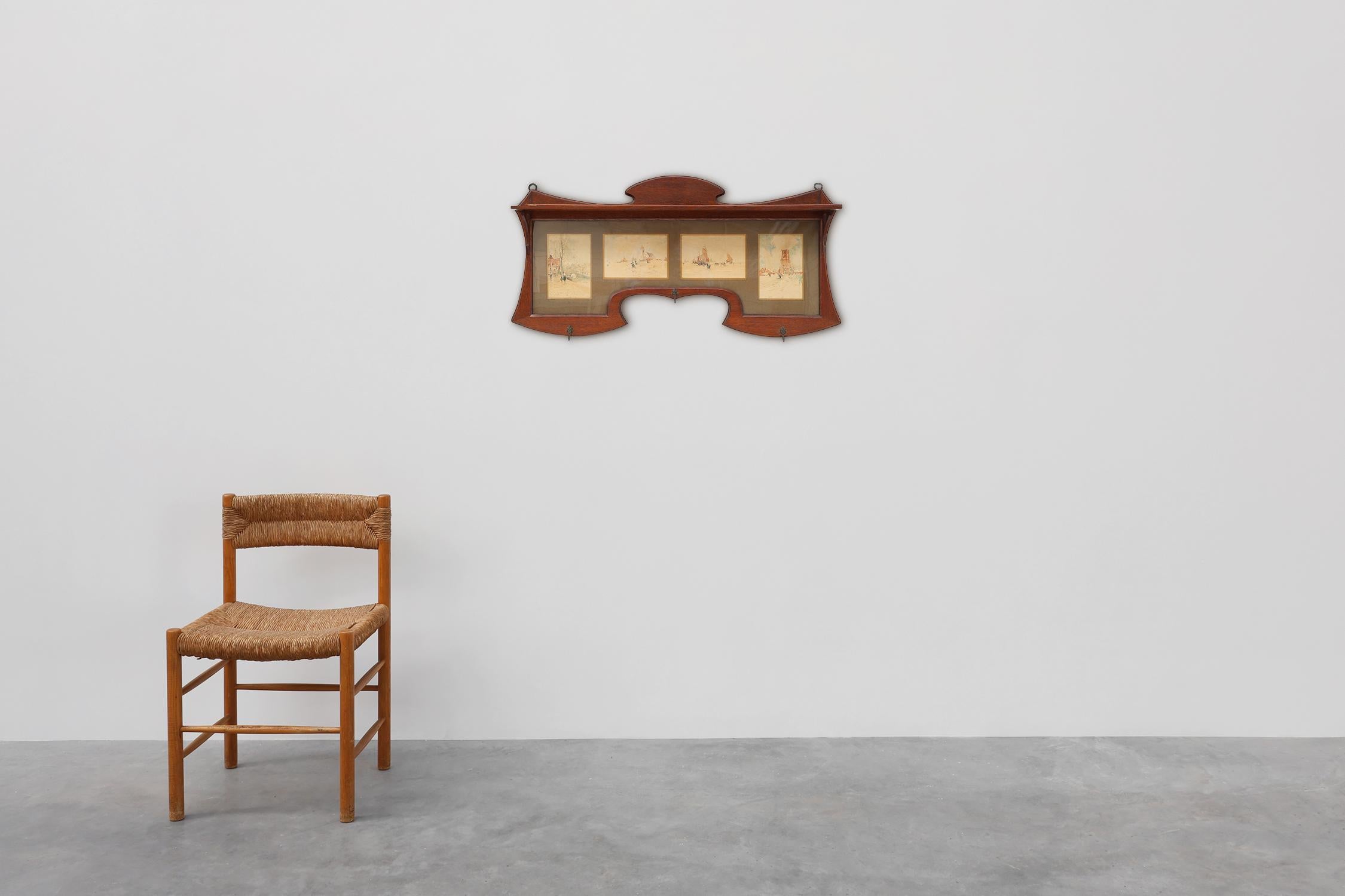 Belgique / 1905 / Porte-manteau / bois, verre, métal, papier / Art Nouveau

Un élégant porte-manteau Art nouveau de Belgique, datant d'environ 1905, combinant fonction et art dans un design raffiné. La pièce est fabriquée en bois richement teinté et